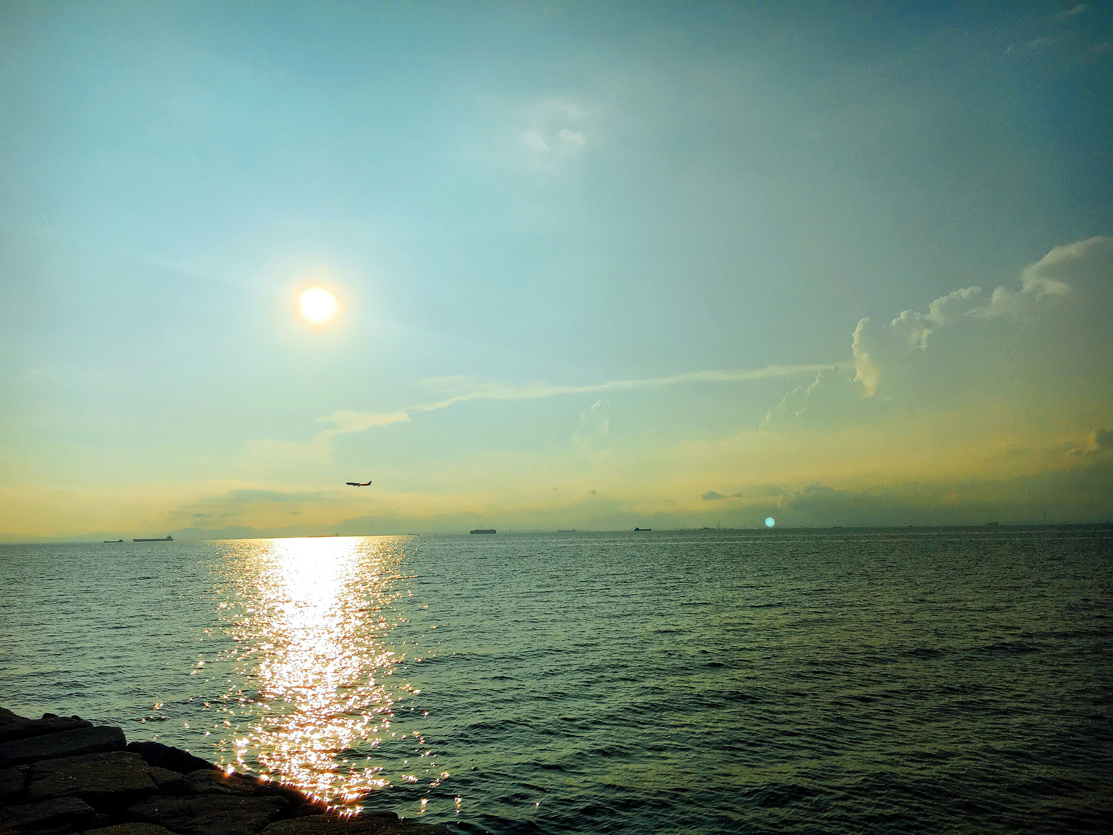 美丽的海景，映照着蓝色海洋上夕阳的柔和光线