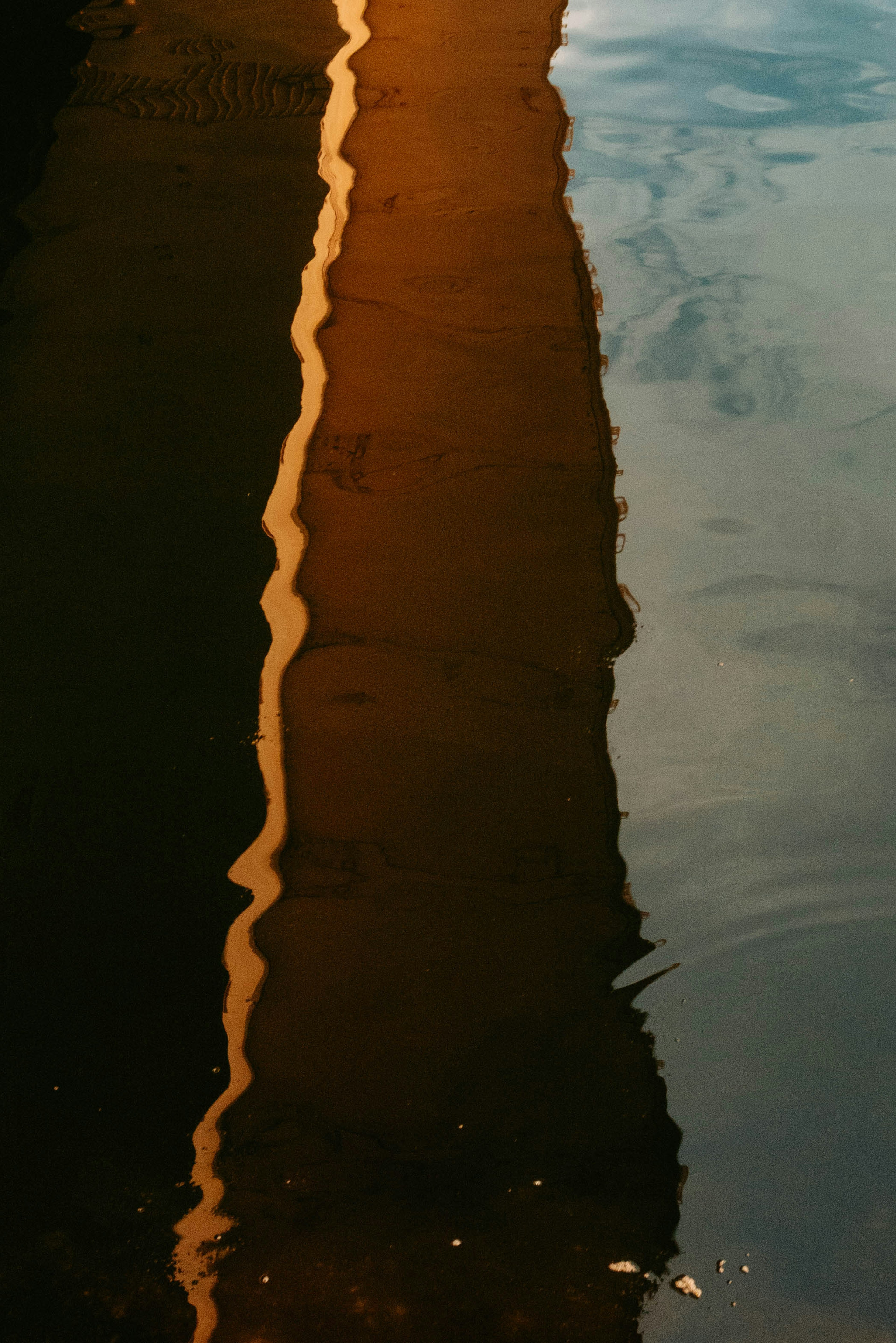 Refleksi garis oranye di atas air dengan permukaan tenang