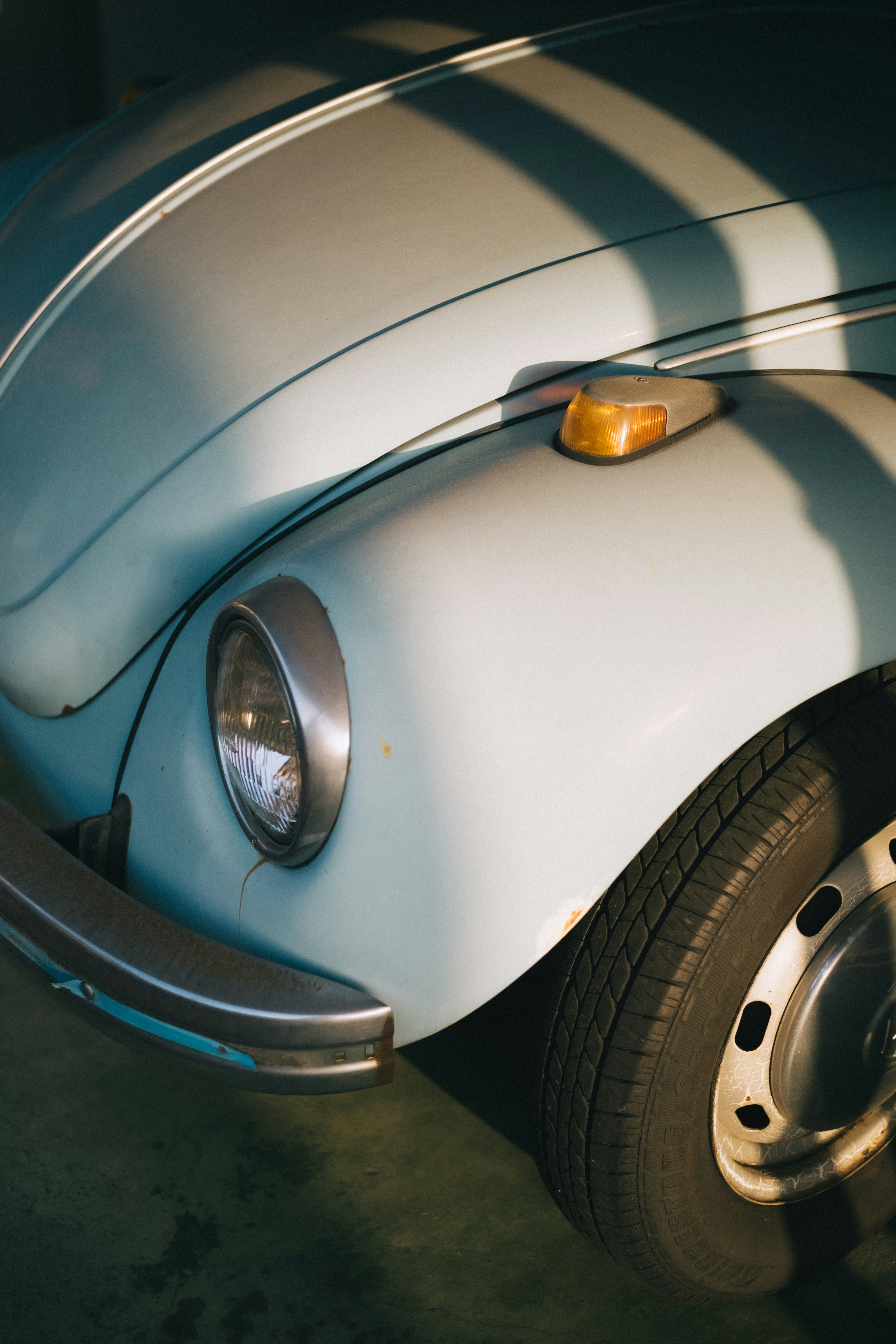 Primo piano di un'auto Beetle blu chiaro che mostra il frontale e il pneumatico