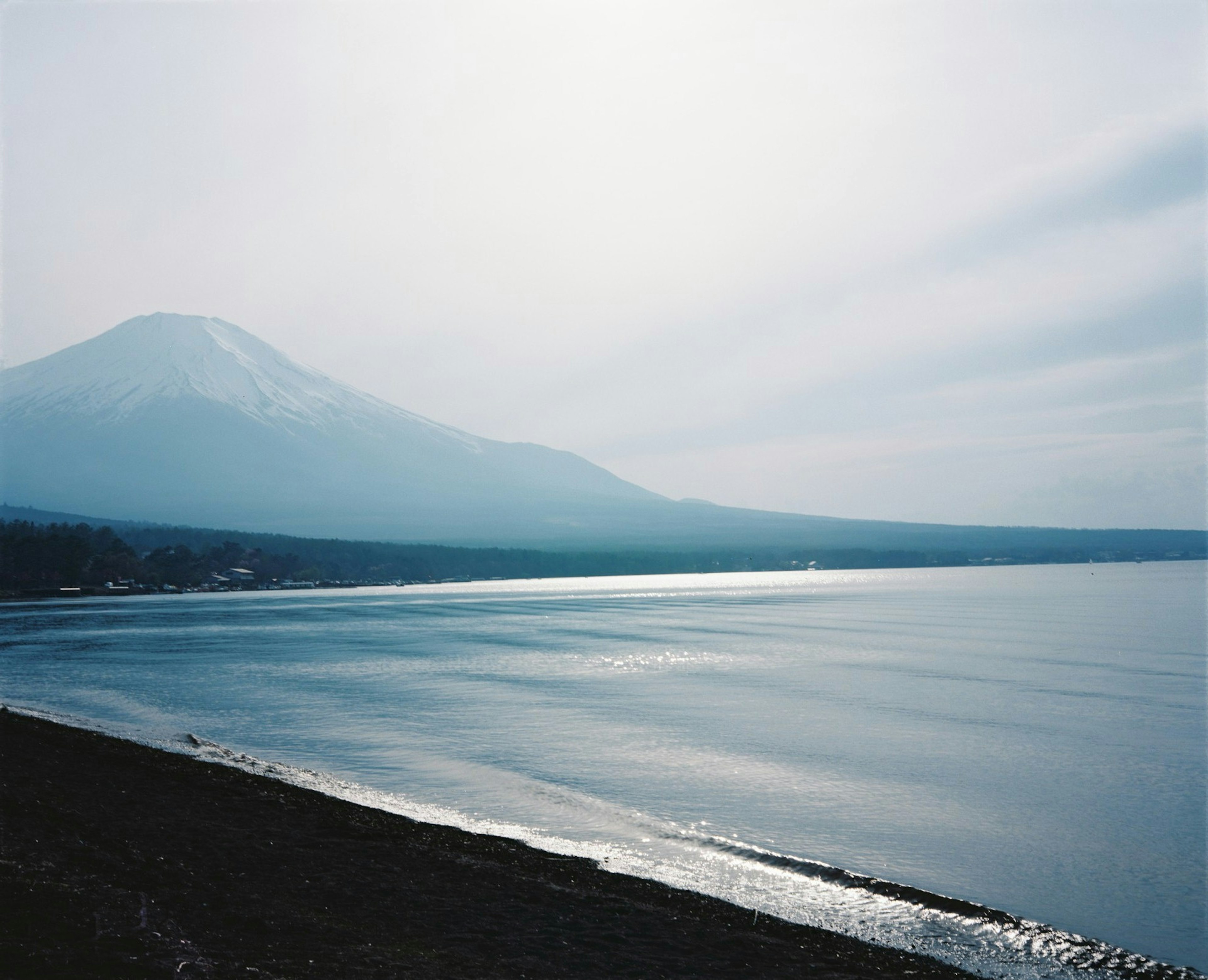 ทิวทัศน์สวยงามของภูเขาฟูจิและชายฝั่งทะเลสาบที่เงียบสงบ