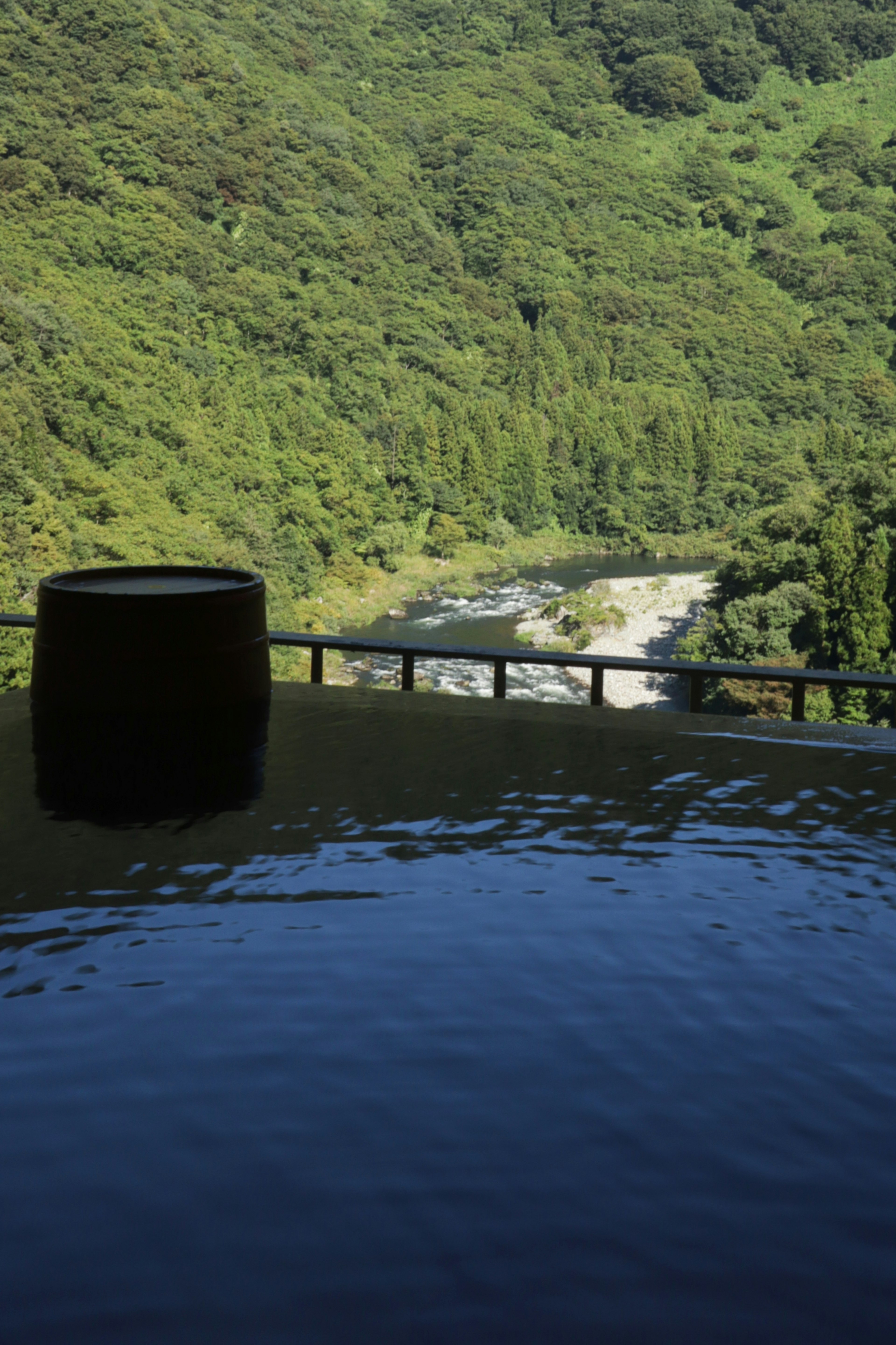 Baño termal al aire libre con vista tranquila de la montaña reflejada en la superficie del agua