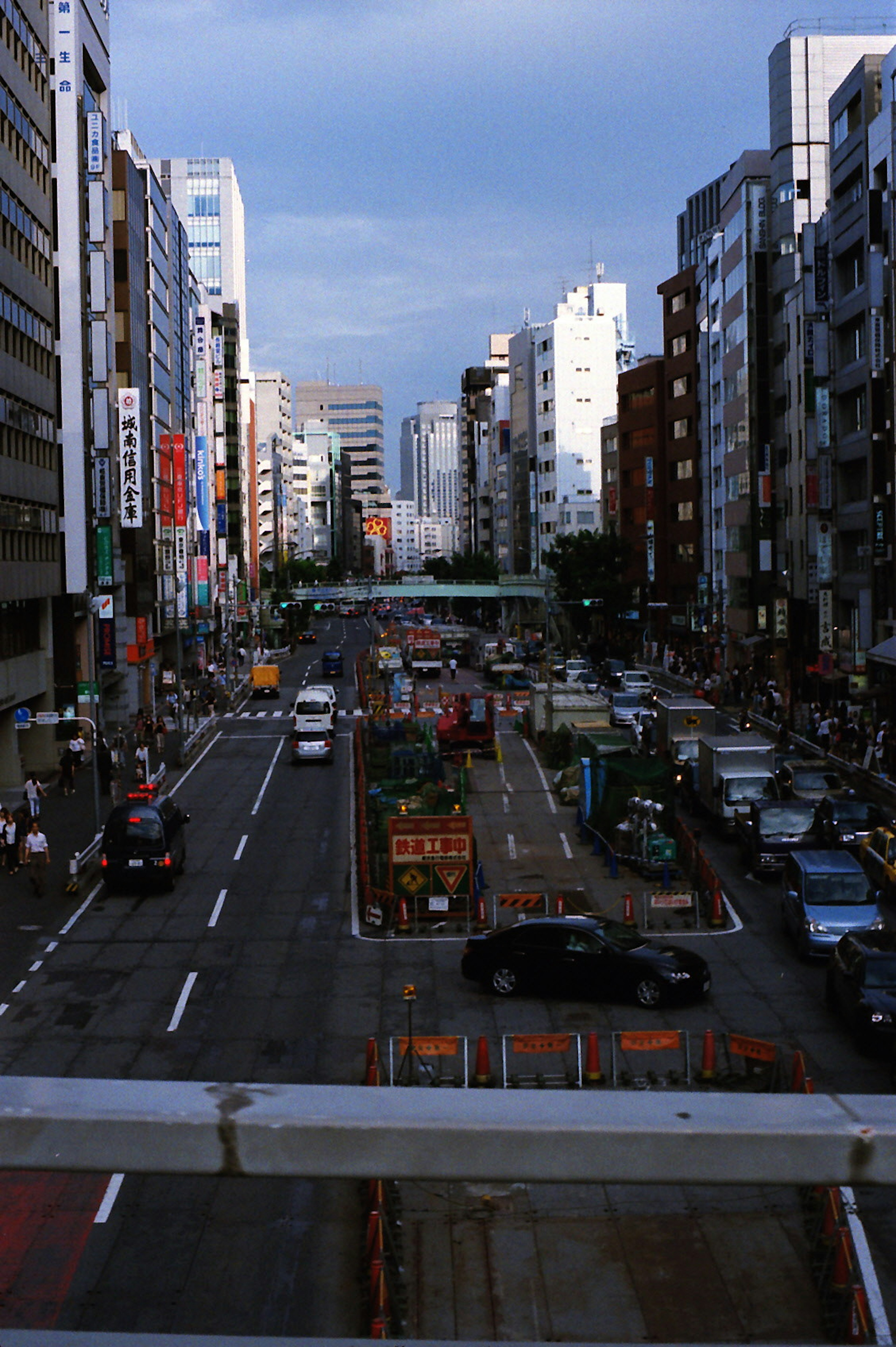 Urban street lined with tall buildings and flowing traffic