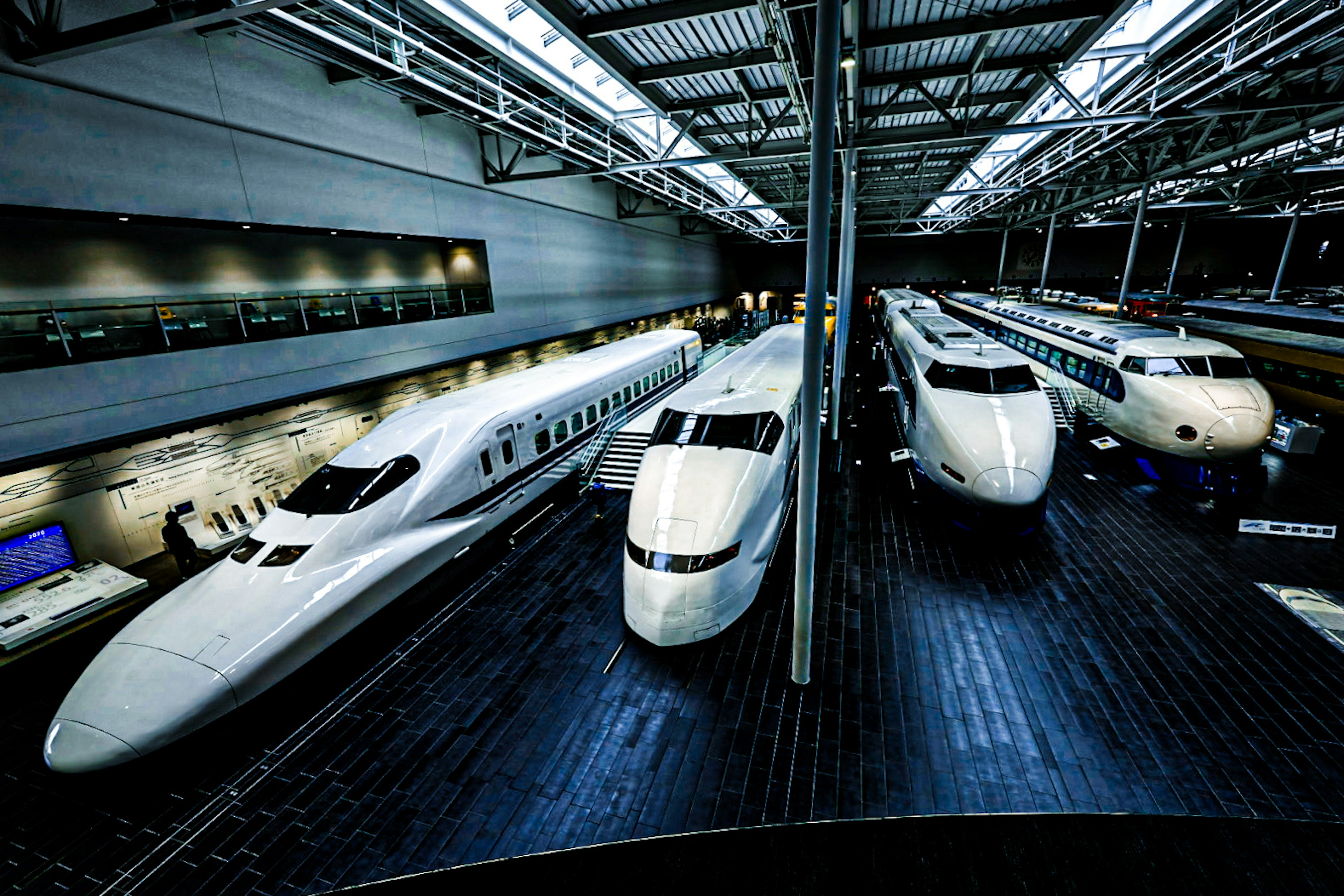 Interior of an aircraft exhibition hall featuring several white airplanes