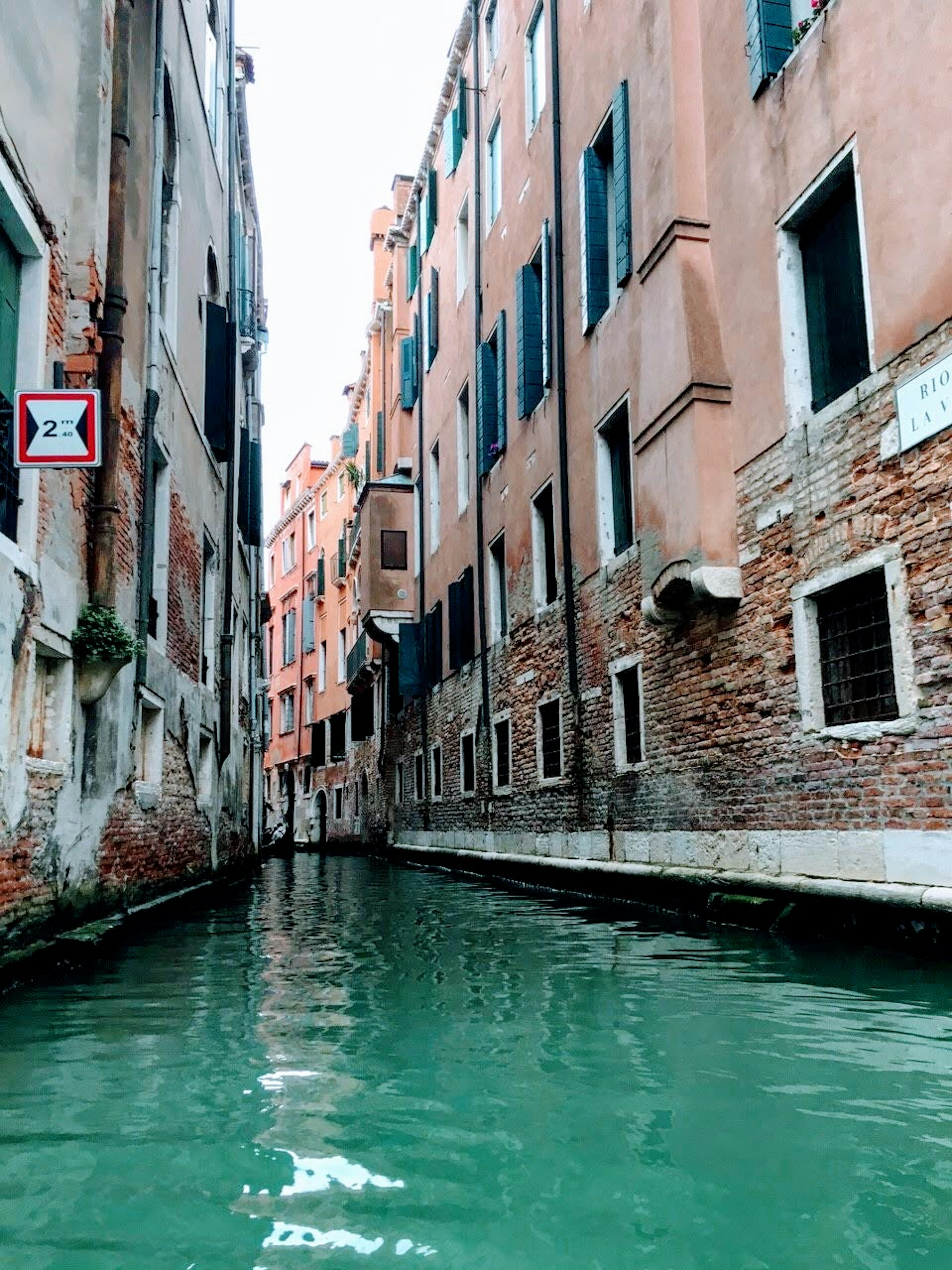 ヴェネツィアの運河の景観 水面に映る建物の影と緑色の水