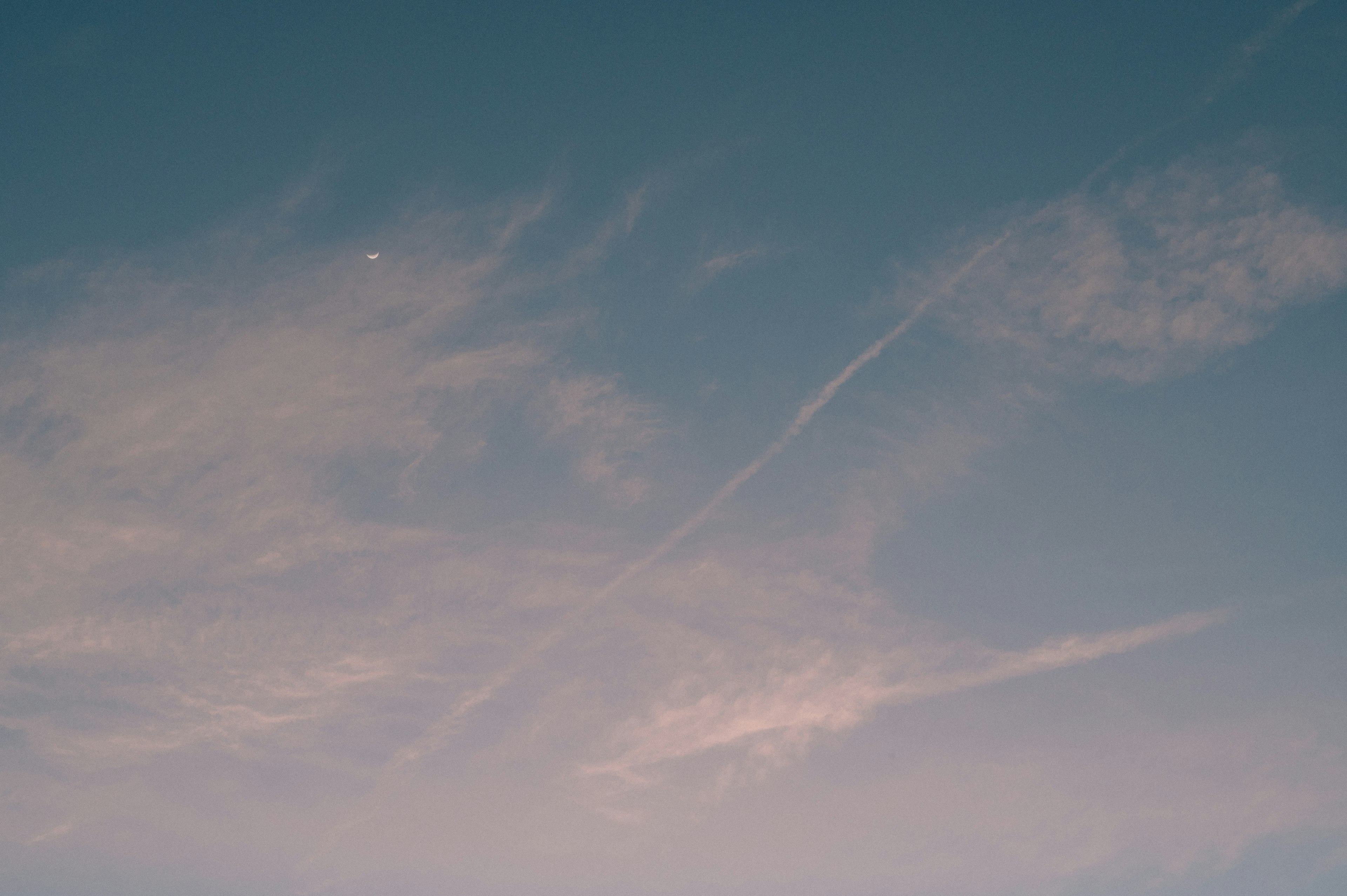 Nuvole leggere e scie di aerei in un cielo blu