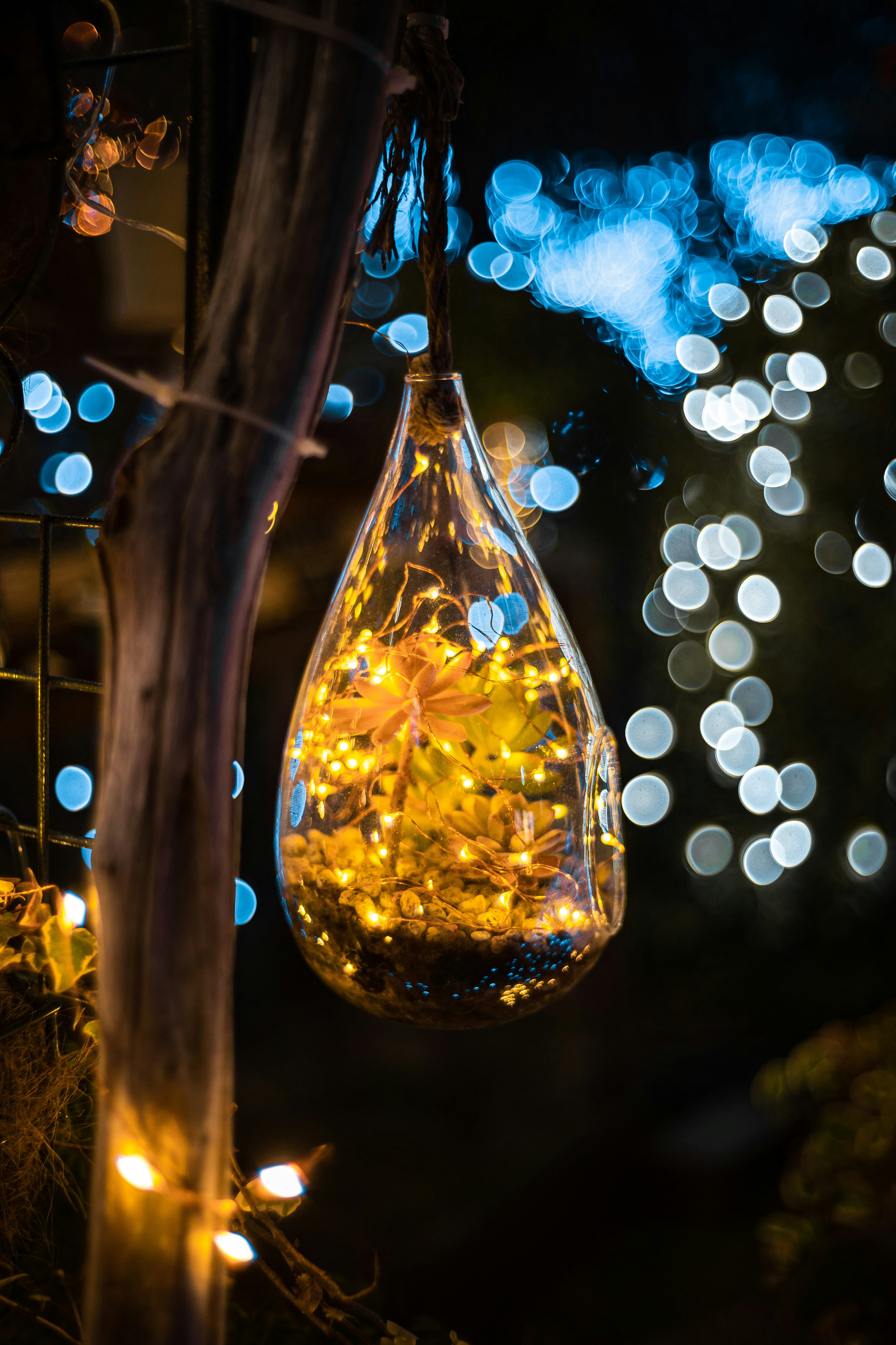 Ornamen kaca diisi cahaya hangat dan latar belakang bokeh biru