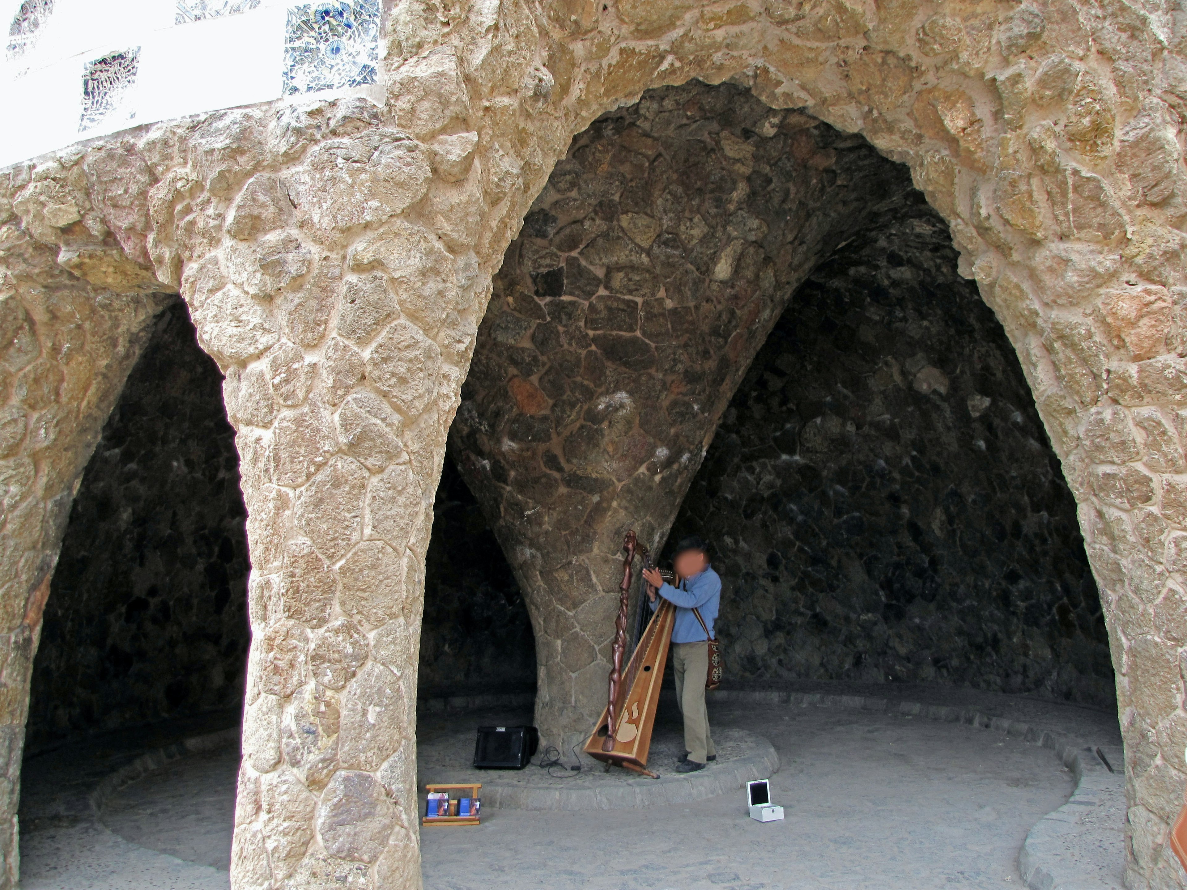 Arcos de piedra con una persona ajustando un instrumento musical