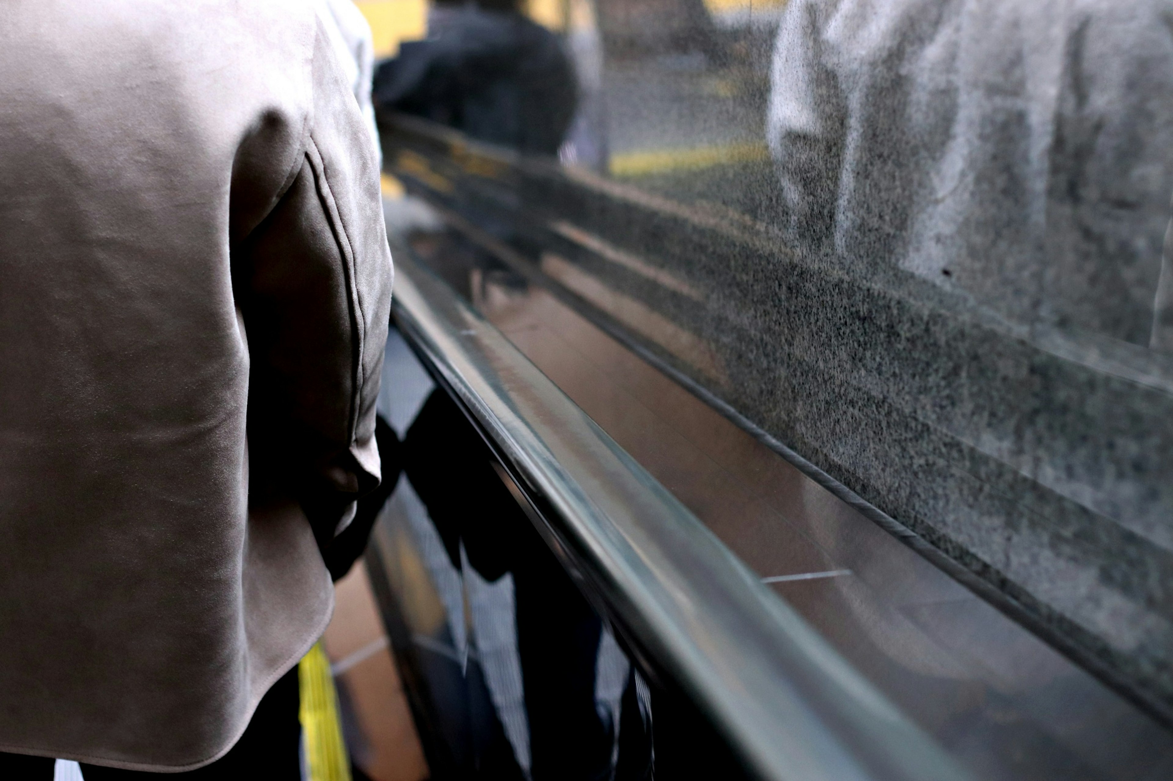 Haut du corps d'une personne s'approchant d'un comptoir avec un reflet de verre visible