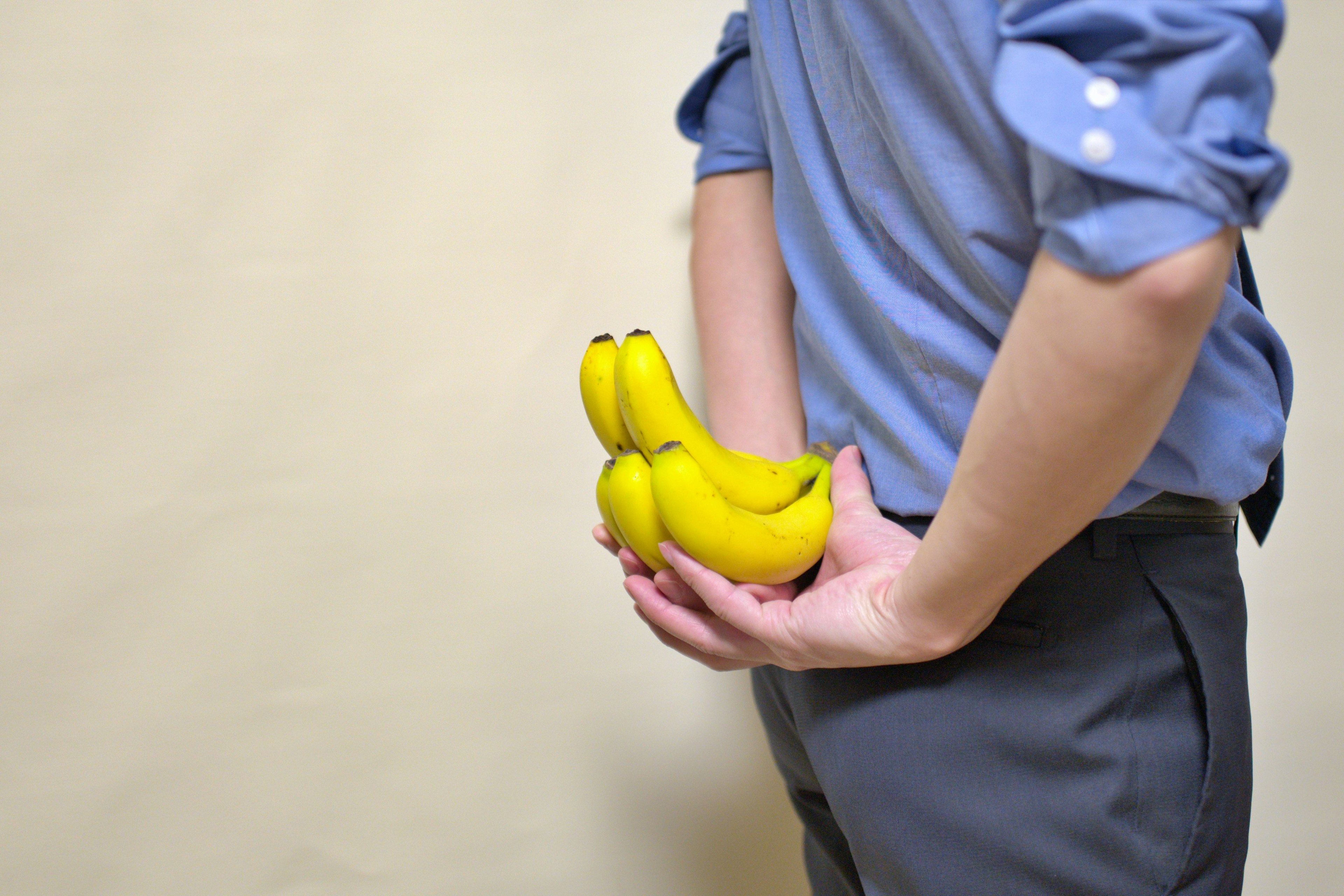 A man hiding bananas behind his back