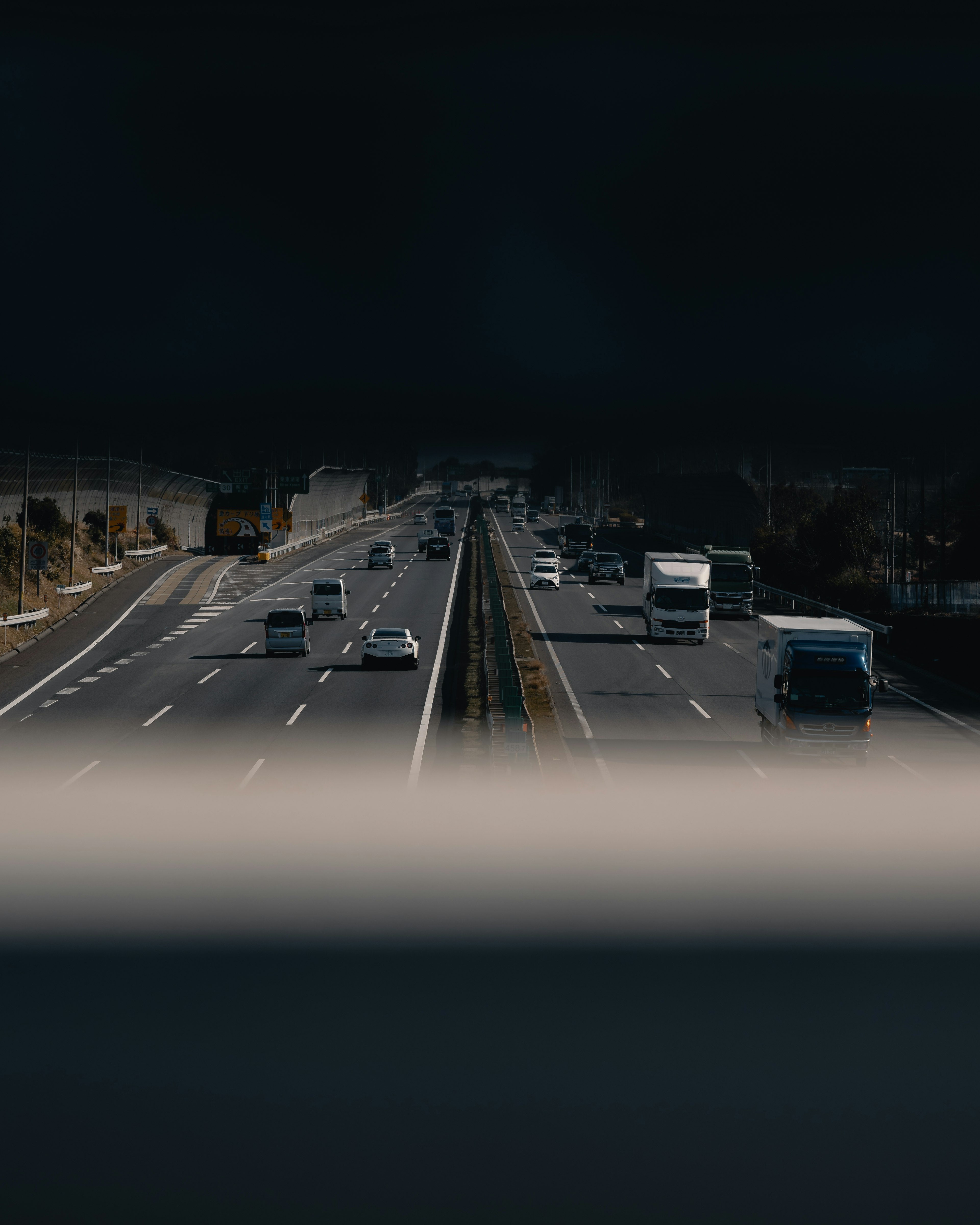 View of vehicles on a highway with a dark overhead