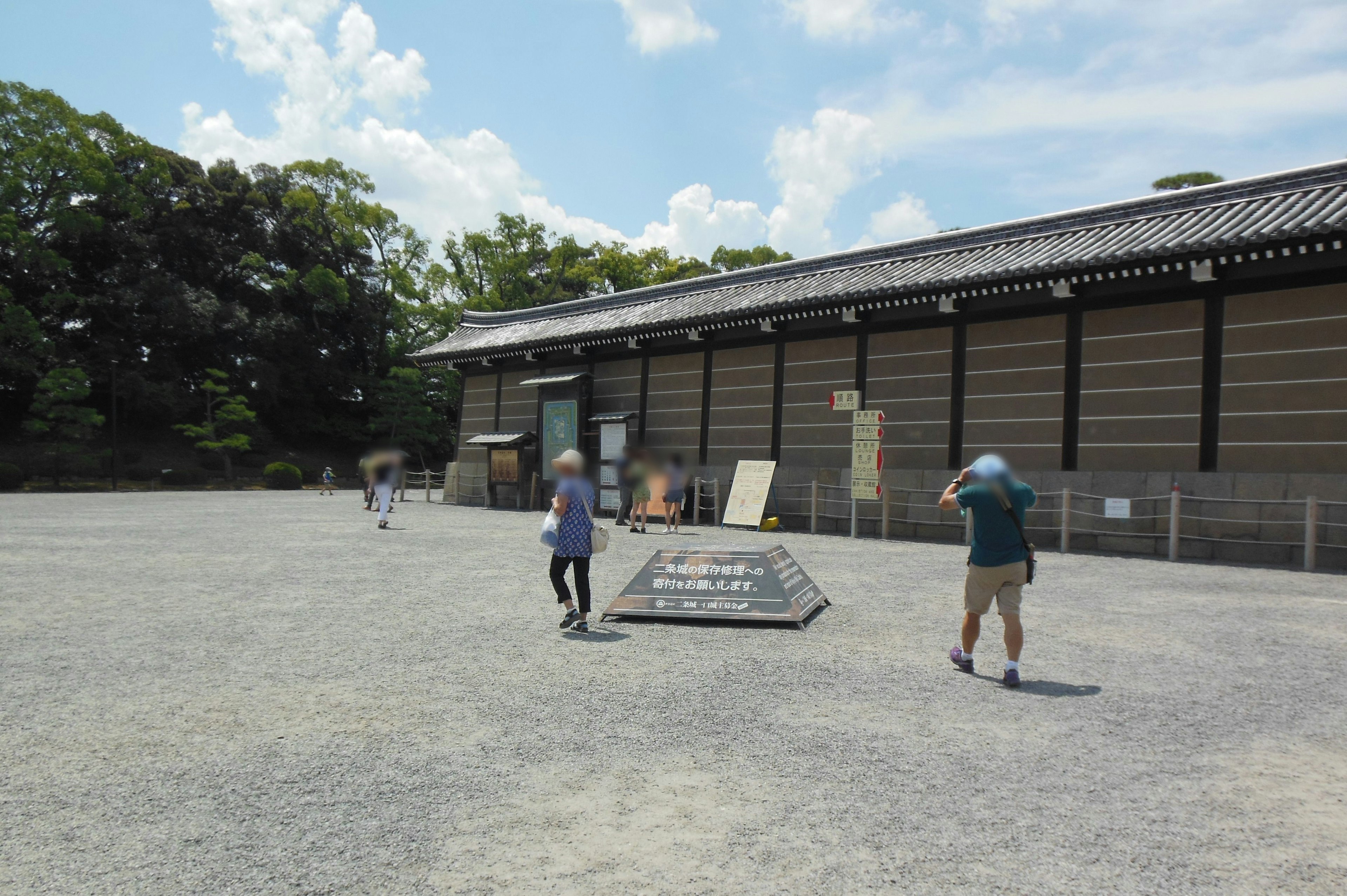 青空の下で人々が歩く歴史的な建物の前の広場