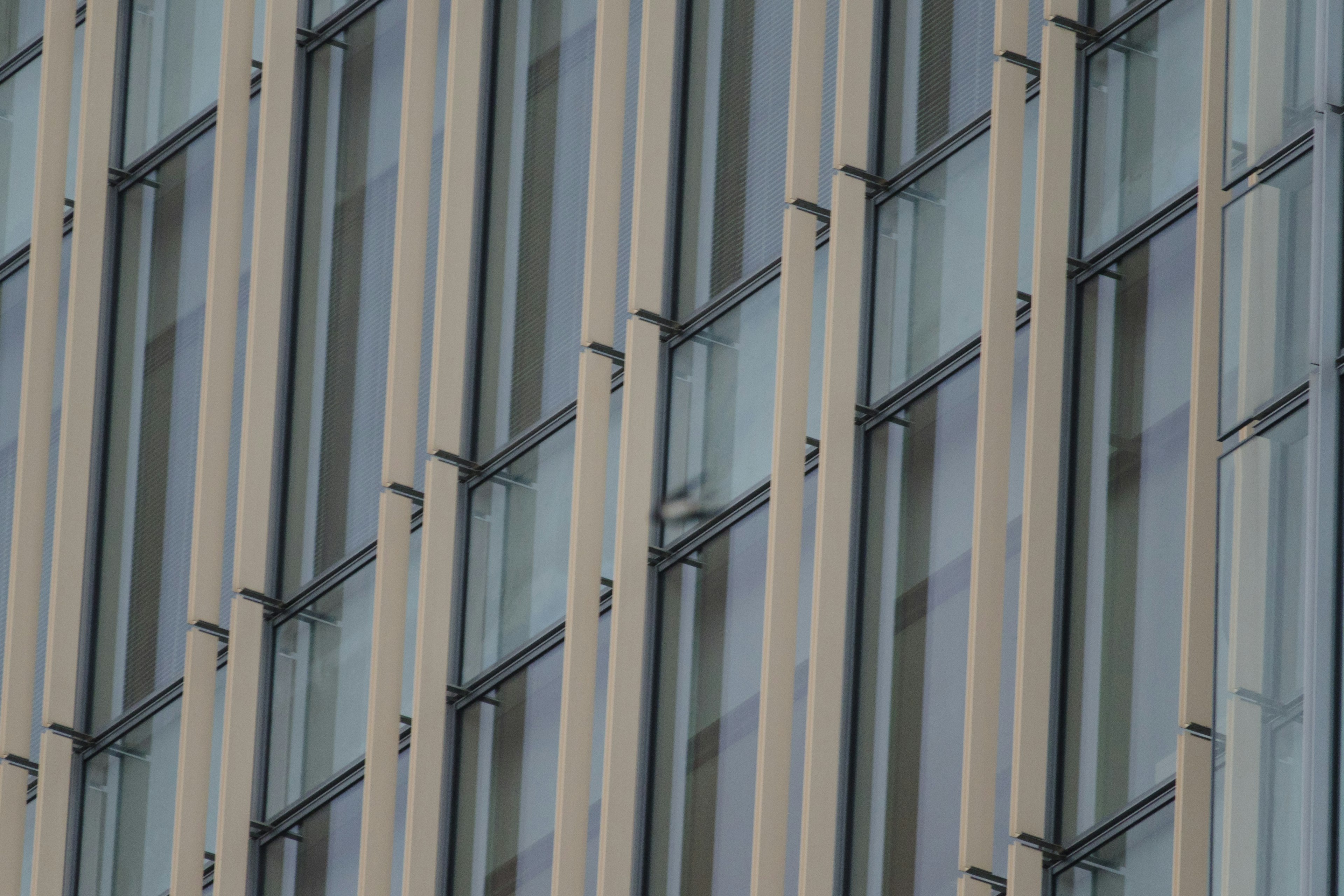 Primer plano de una fachada de edificio con franjas de vidrio y metal