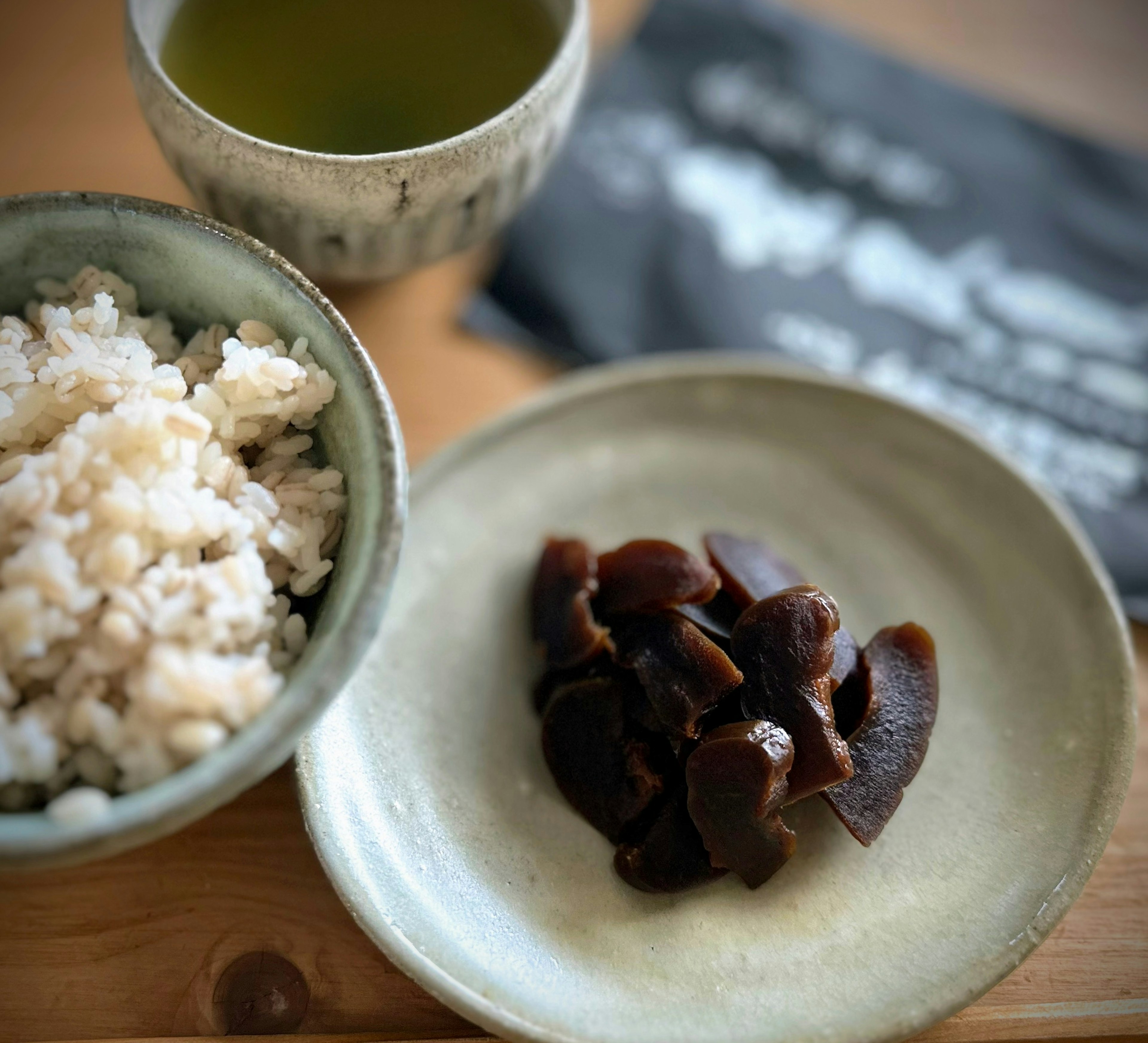 Japanese meal featuring rice in a bowl and mushrooms on a plate with green tea