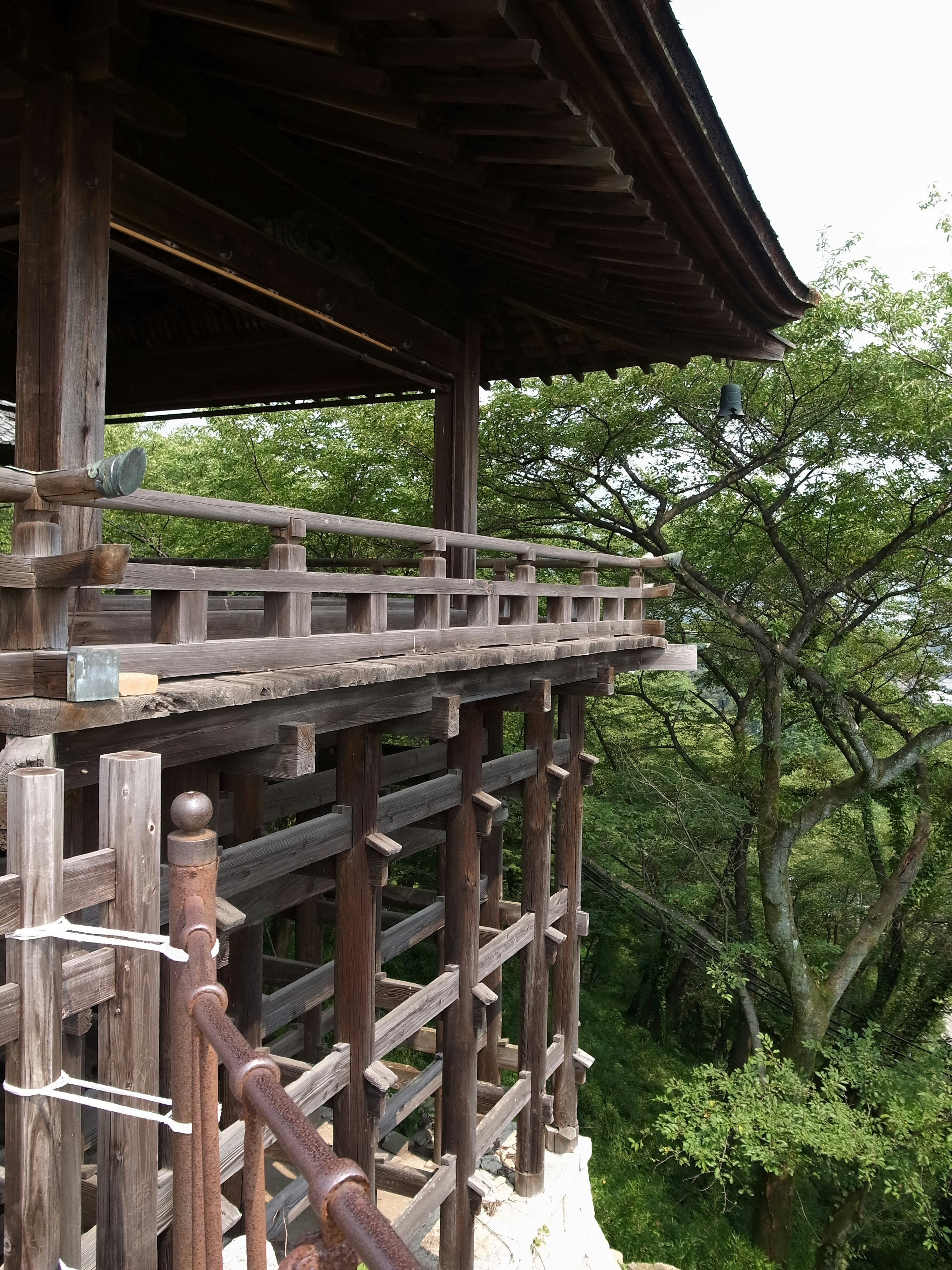 Balcon en bois d'un bâtiment avec des arbres verts luxuriants en arrière-plan