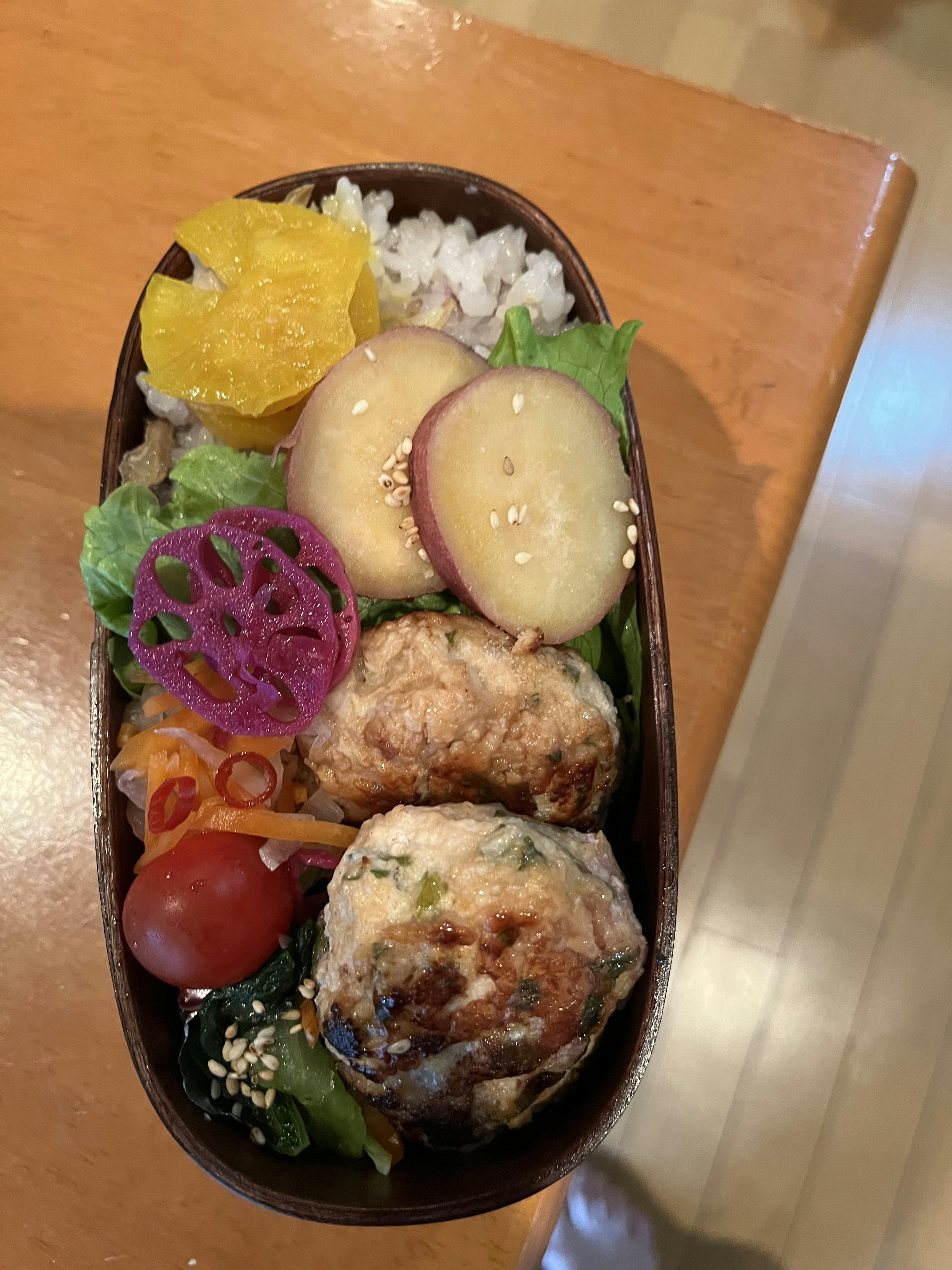 カラフルな弁当箱に盛り付けられた焼き魚と野菜の盛り合わせ