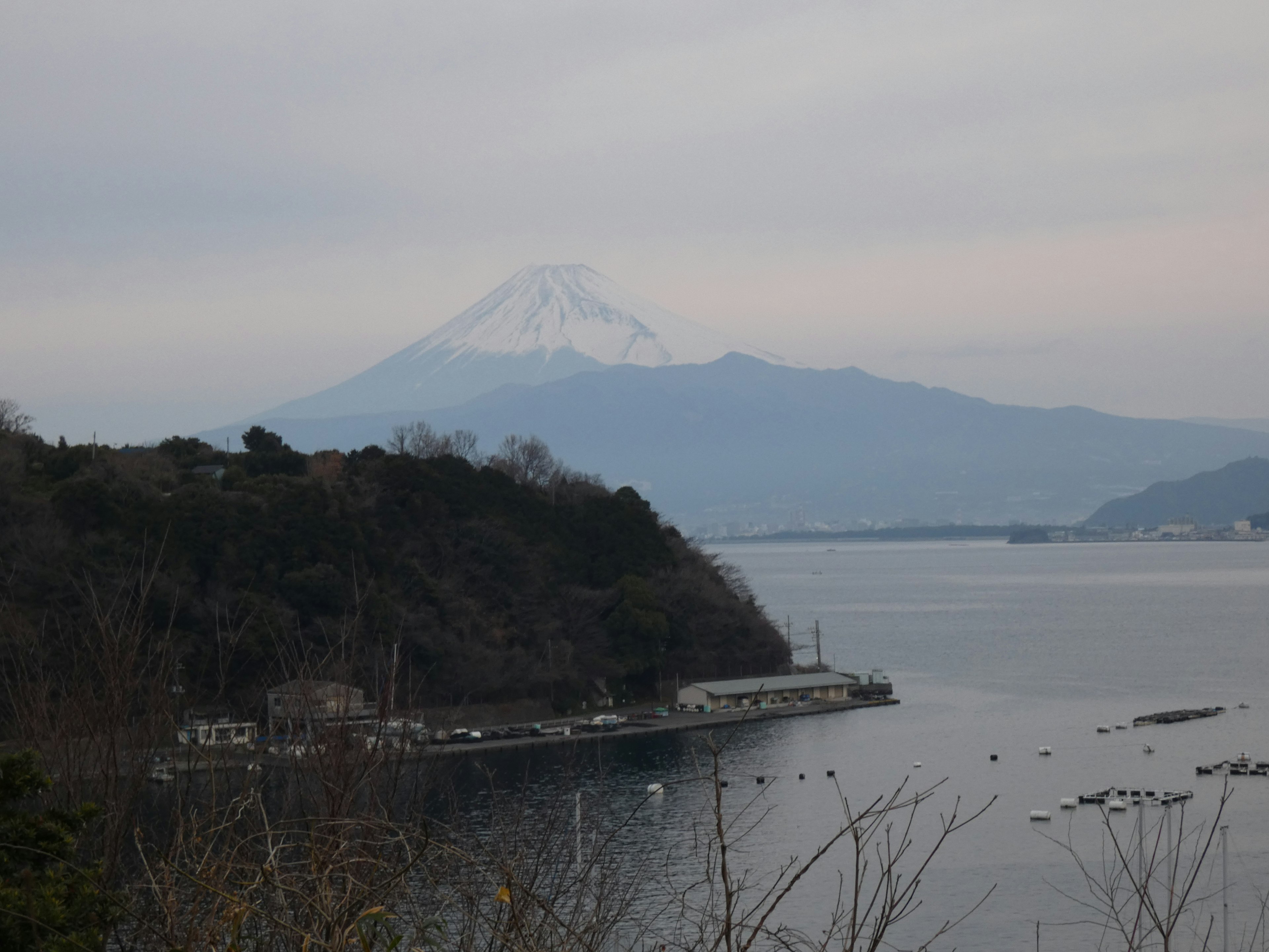 Distant view of Mount Fuji over a calm sea landscape