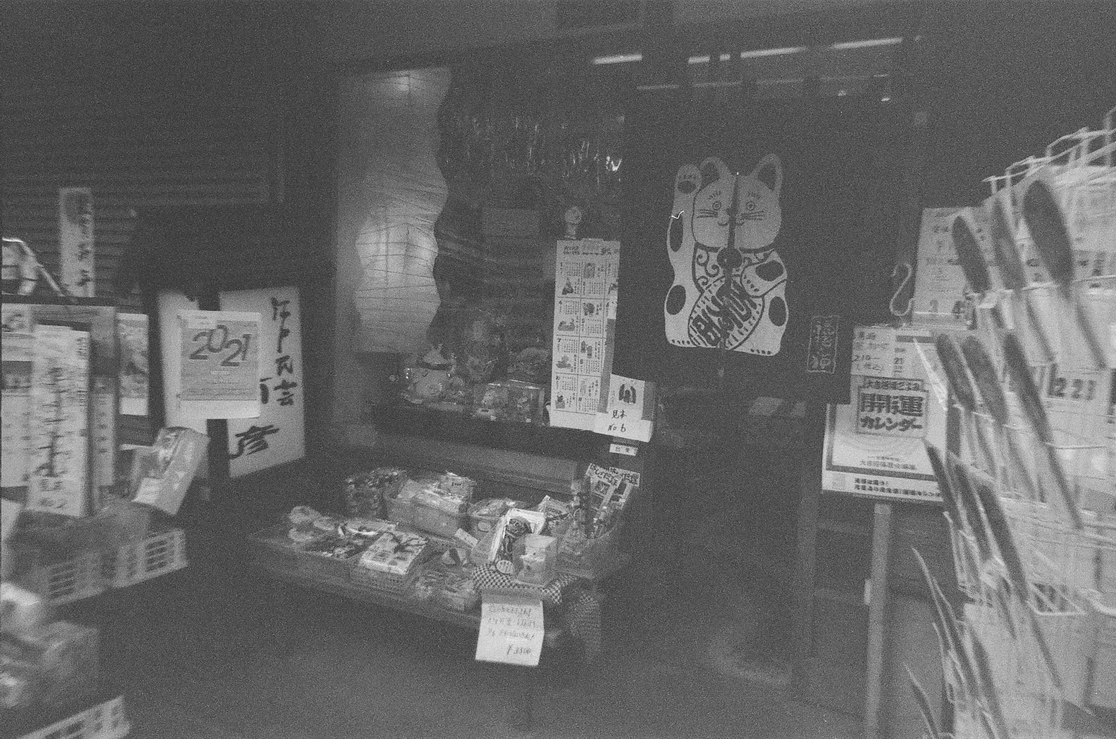 Vitrine de magasin en noir et blanc affichant des produits et des affiches