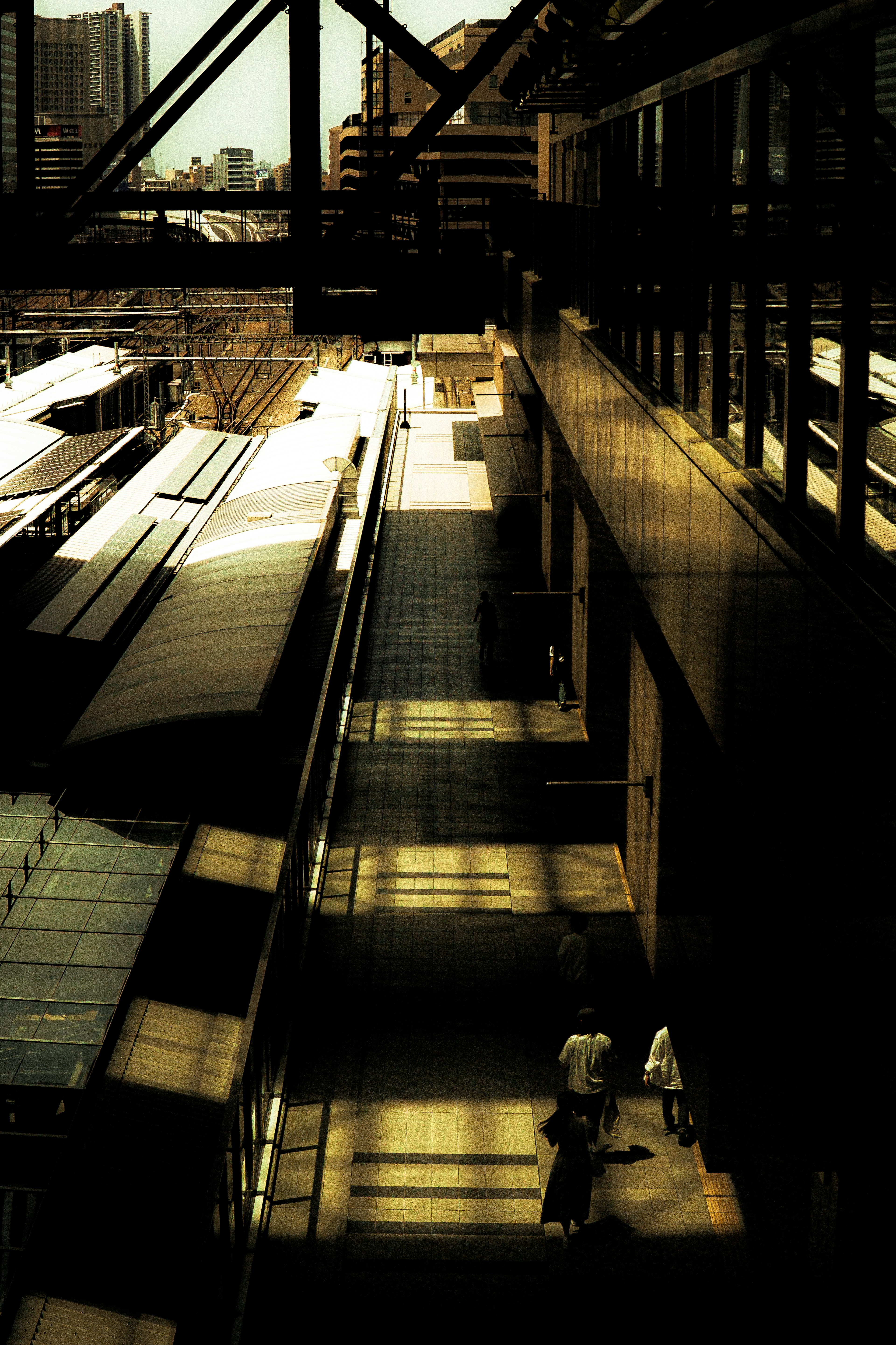 Urban landscape featuring train platforms and shadows of pedestrians