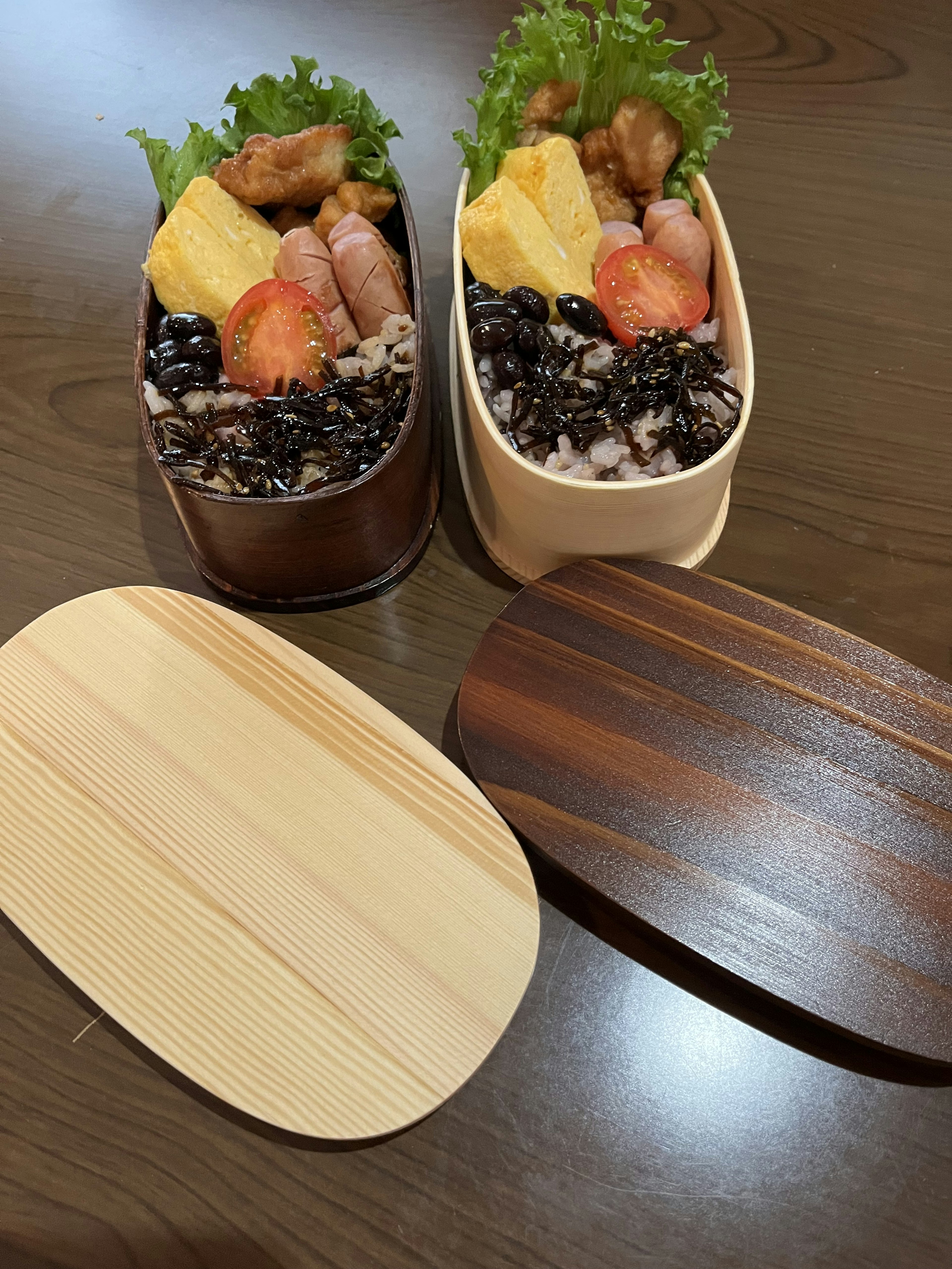 Dos cajas de bento coloridas con una tapa de madera