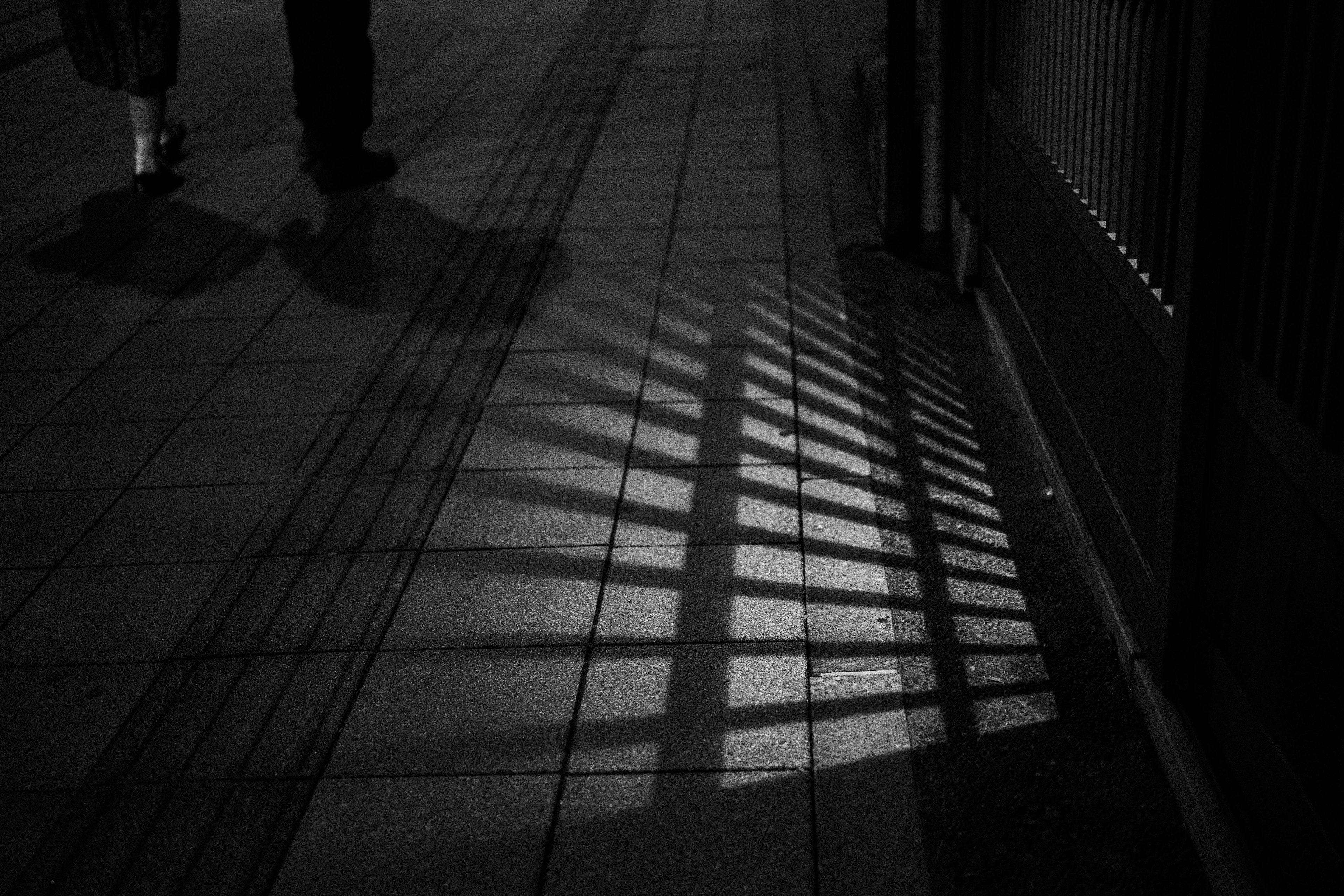 Silhouettes de personnes marchant la nuit avec des ombres en grille qui se croisent