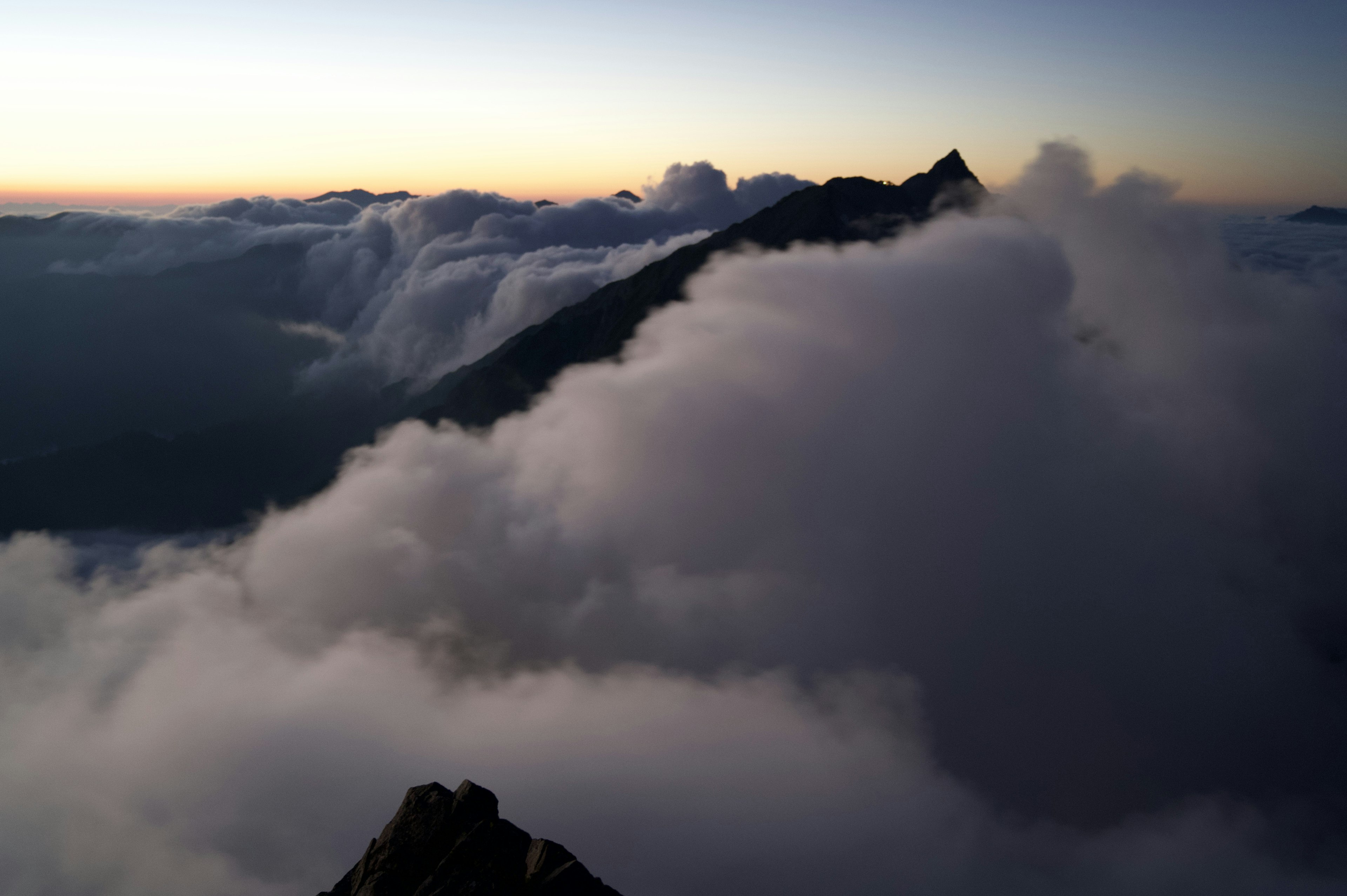 Paysage de montagne couvert de nuages avec un ciel au coucher de soleil