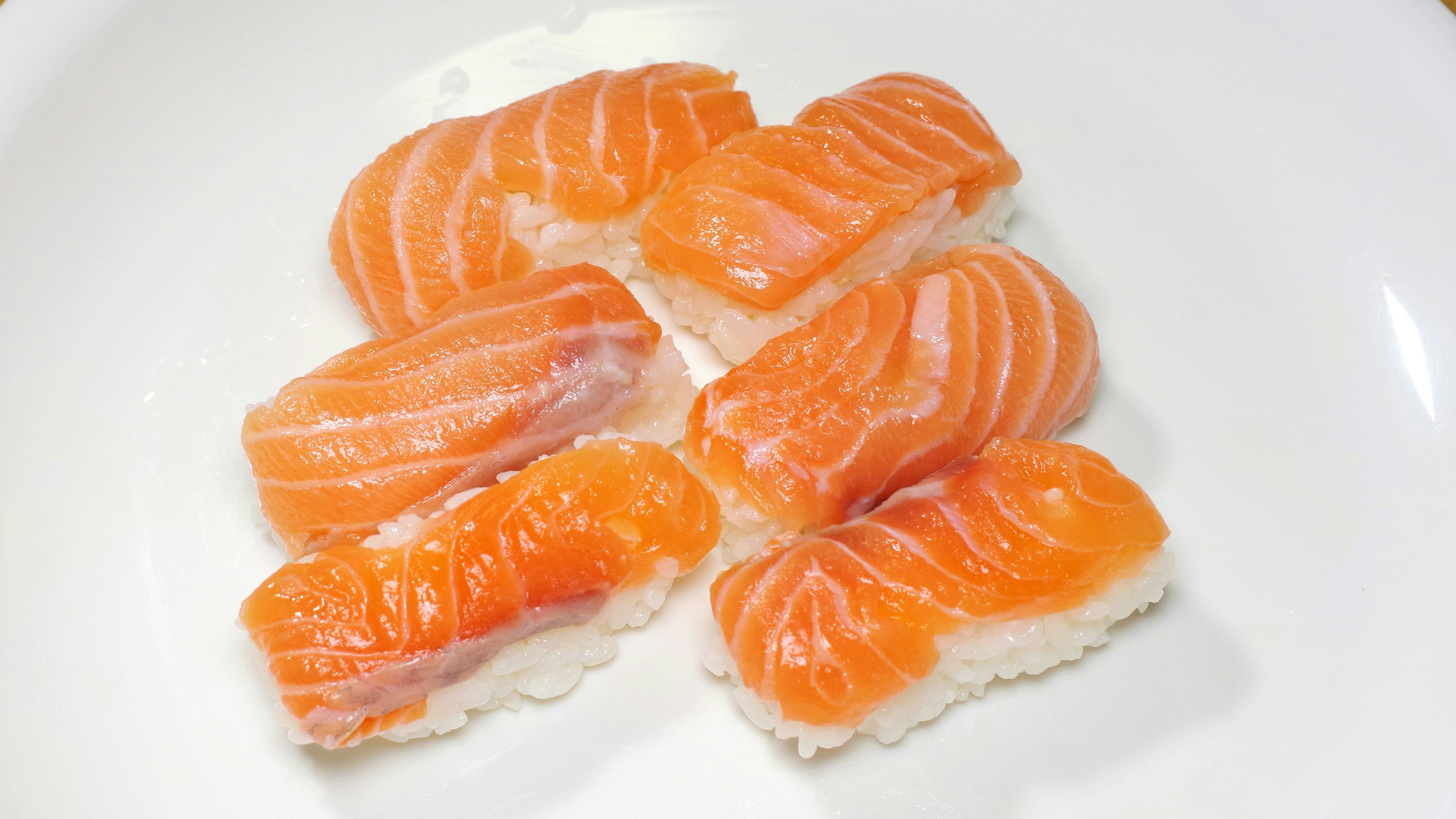 A plate of salmon nigiri sushi arranged neatly