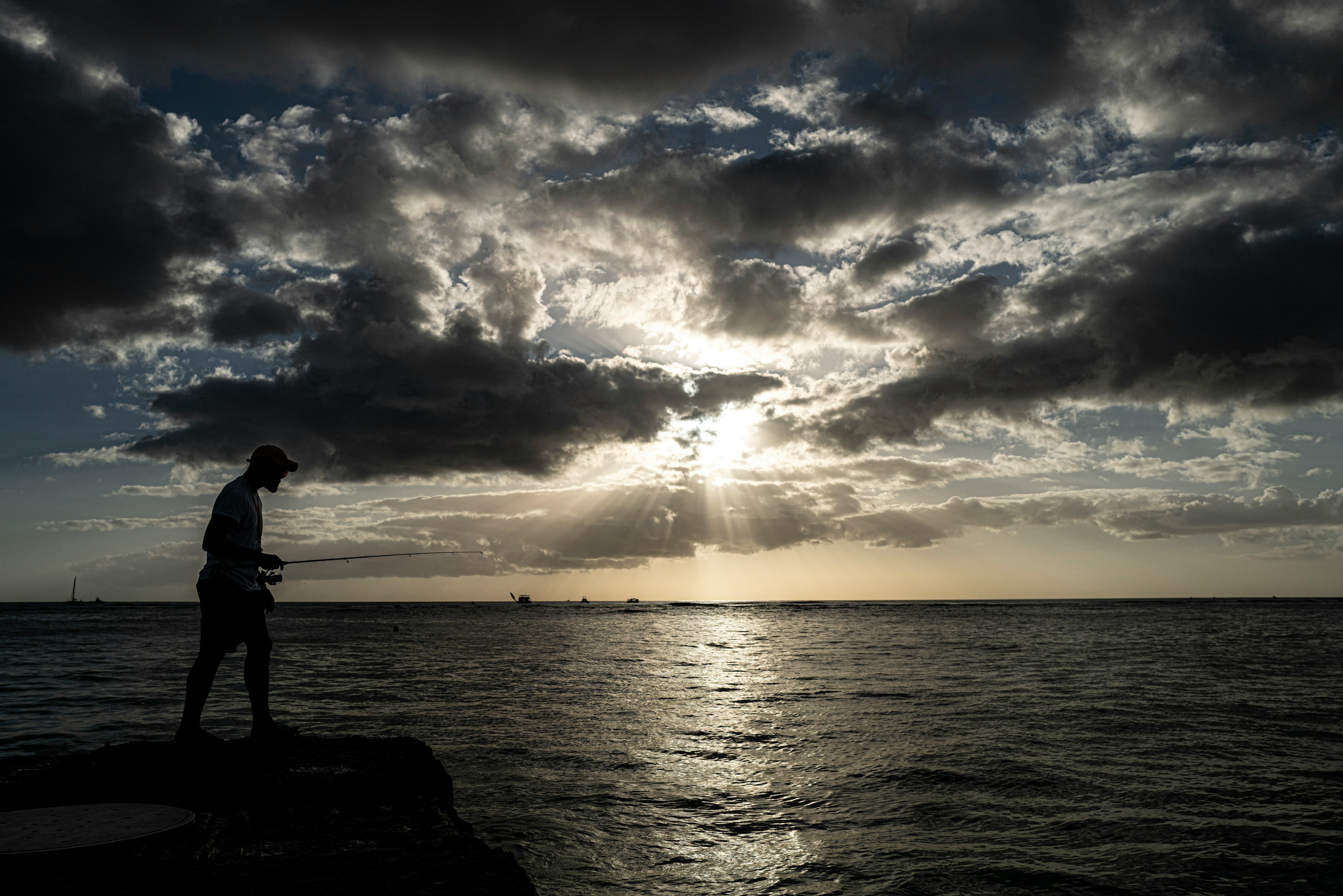 夕日を背にした海辺で歩く男性のシルエット