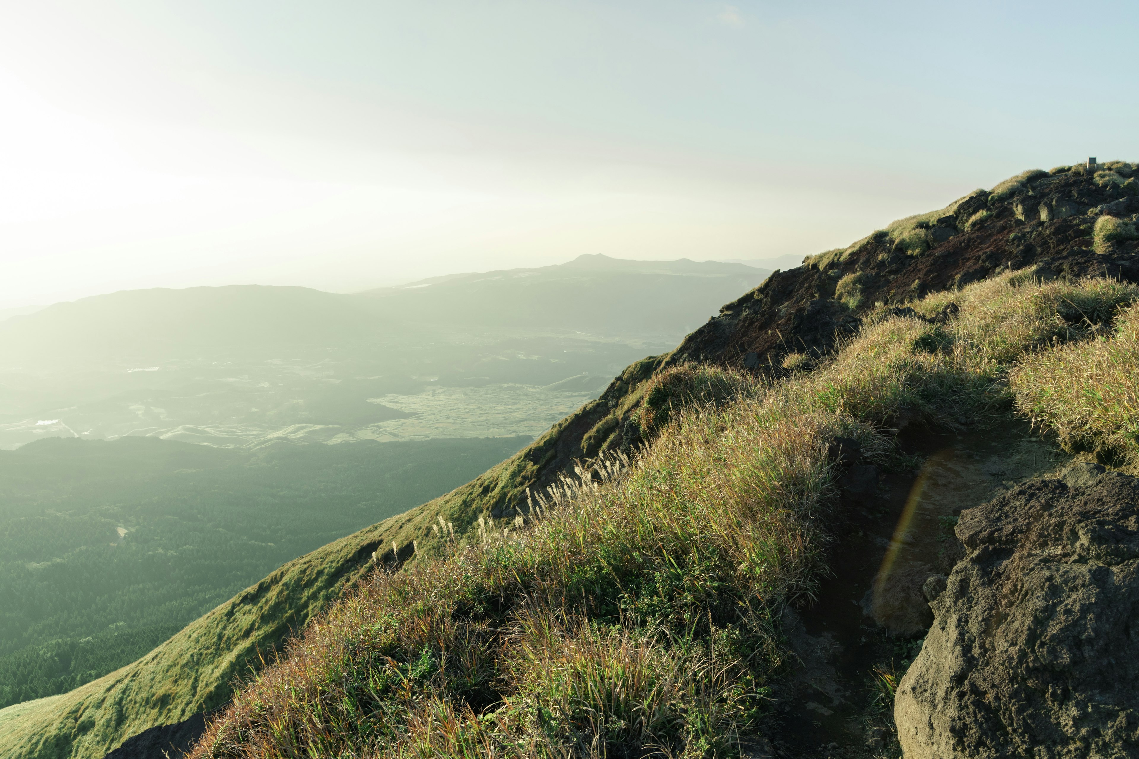 Pemandangan indah lereng gunung dengan rumput hijau dan medan berbatu