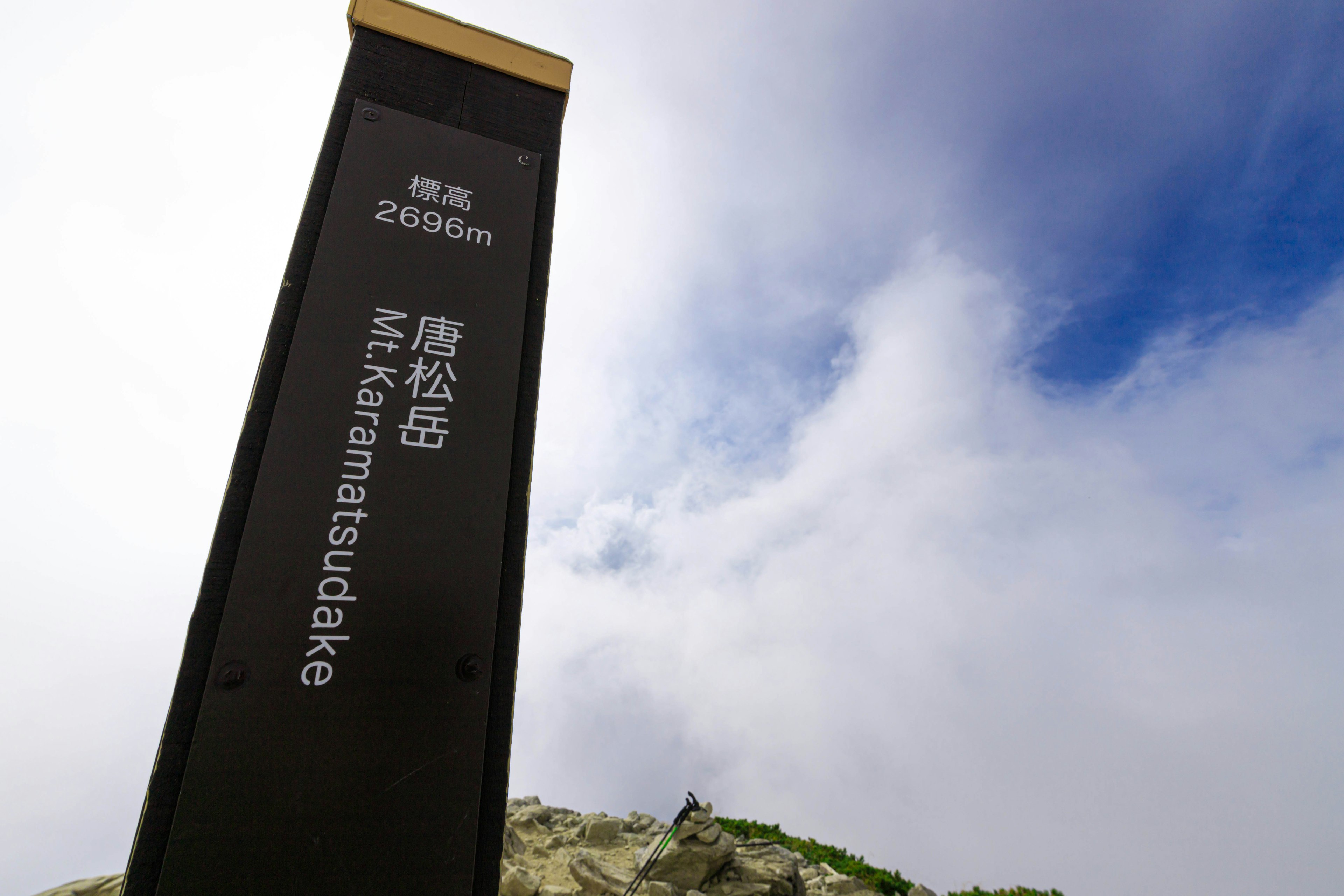 Sign for Mount Karamatsudake at 2990 meters elevation with blue sky