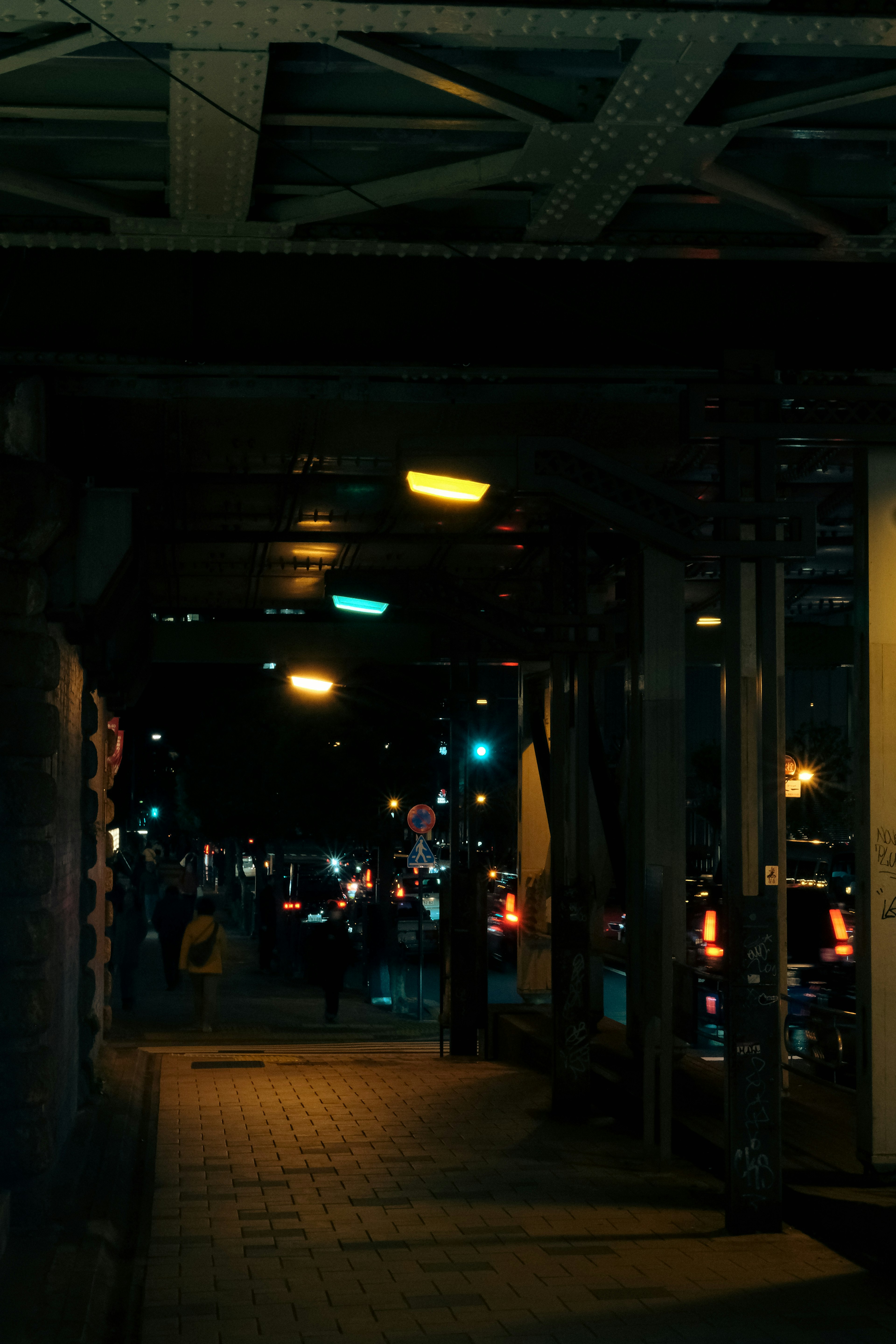 View of a dimly lit walkway lined with vibrant neon lights