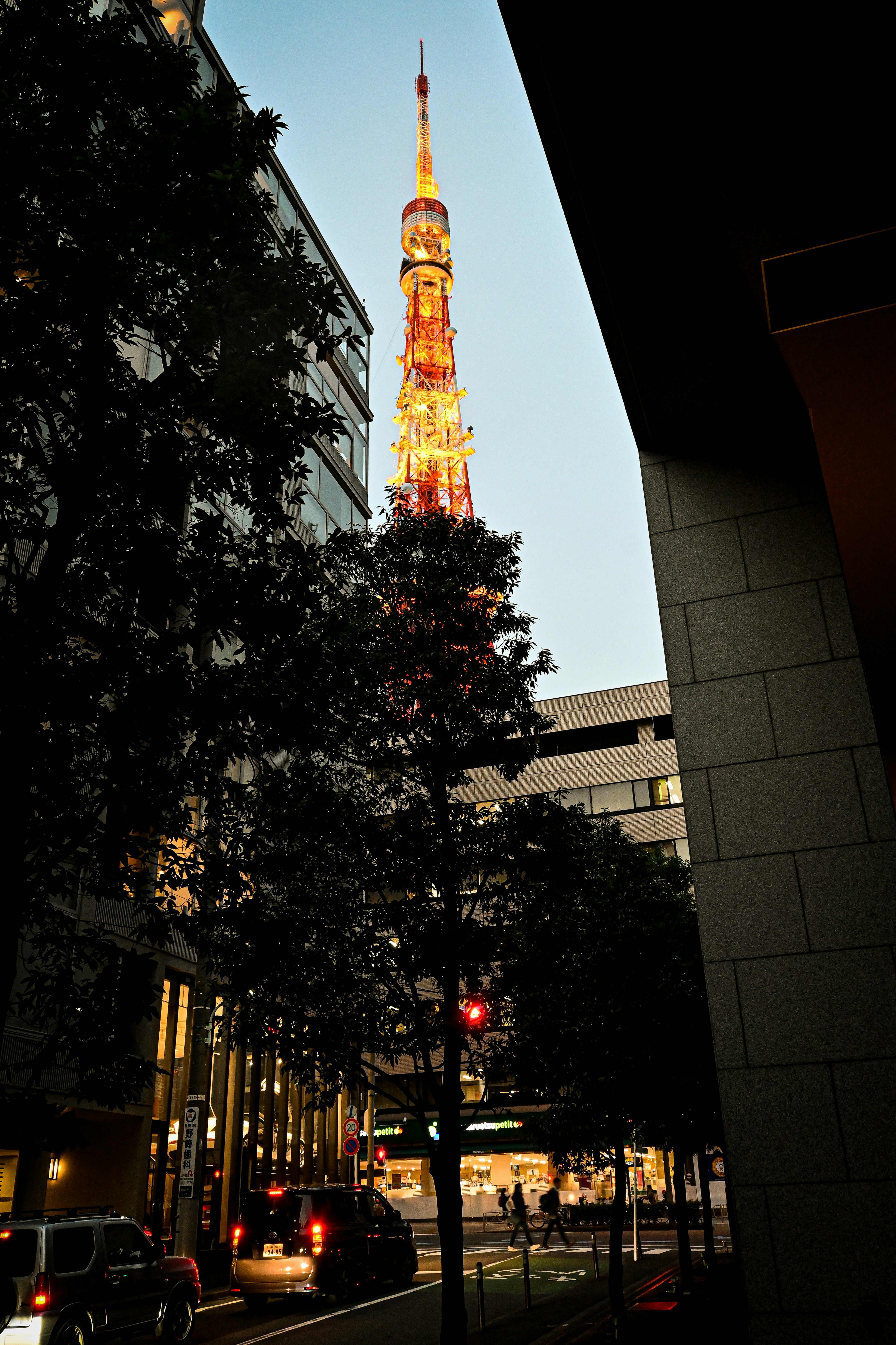 Tokyo Tower illuminated during twilight with city buildings