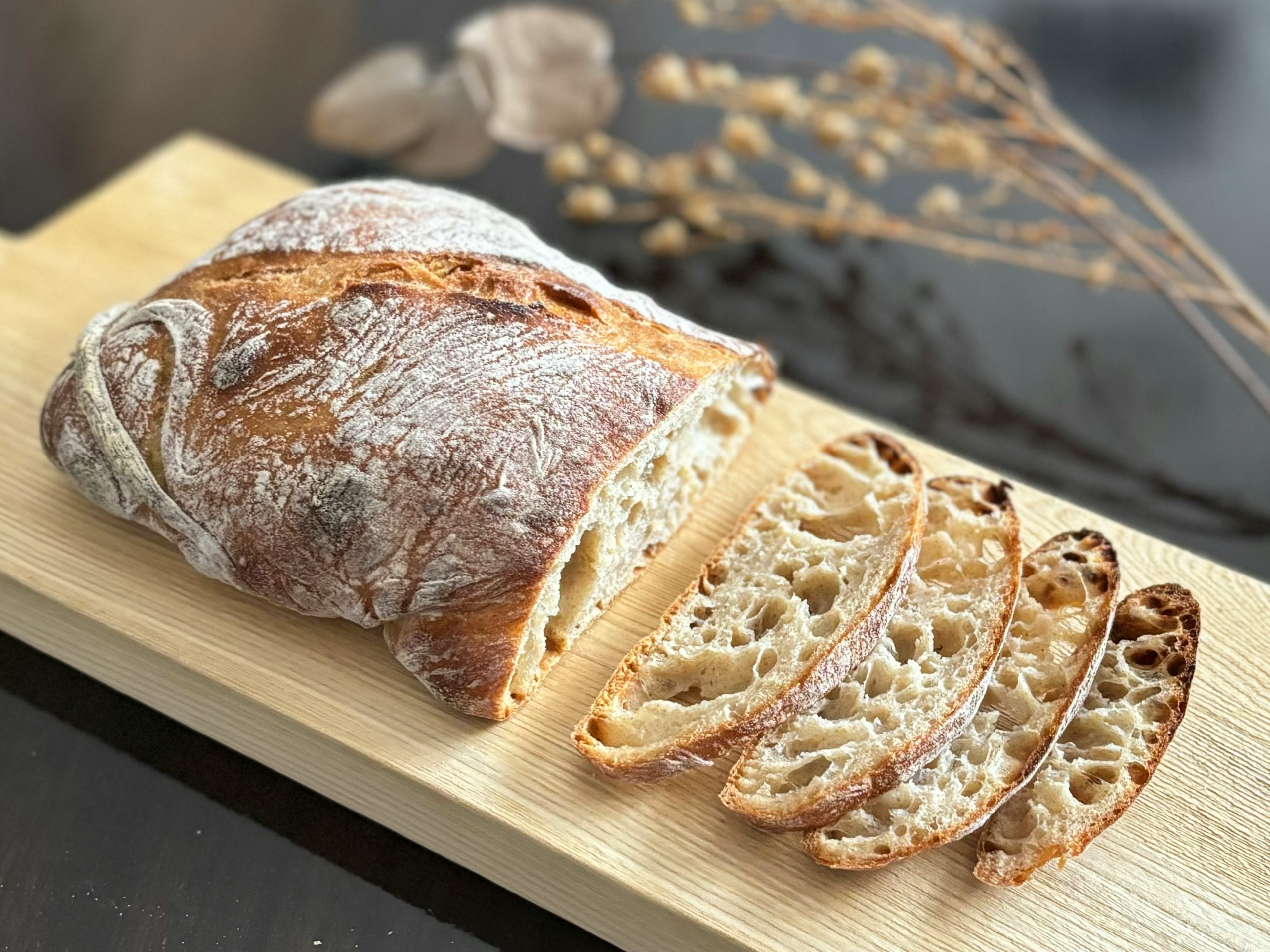 Freshly baked bread with slices displayed on a wooden board