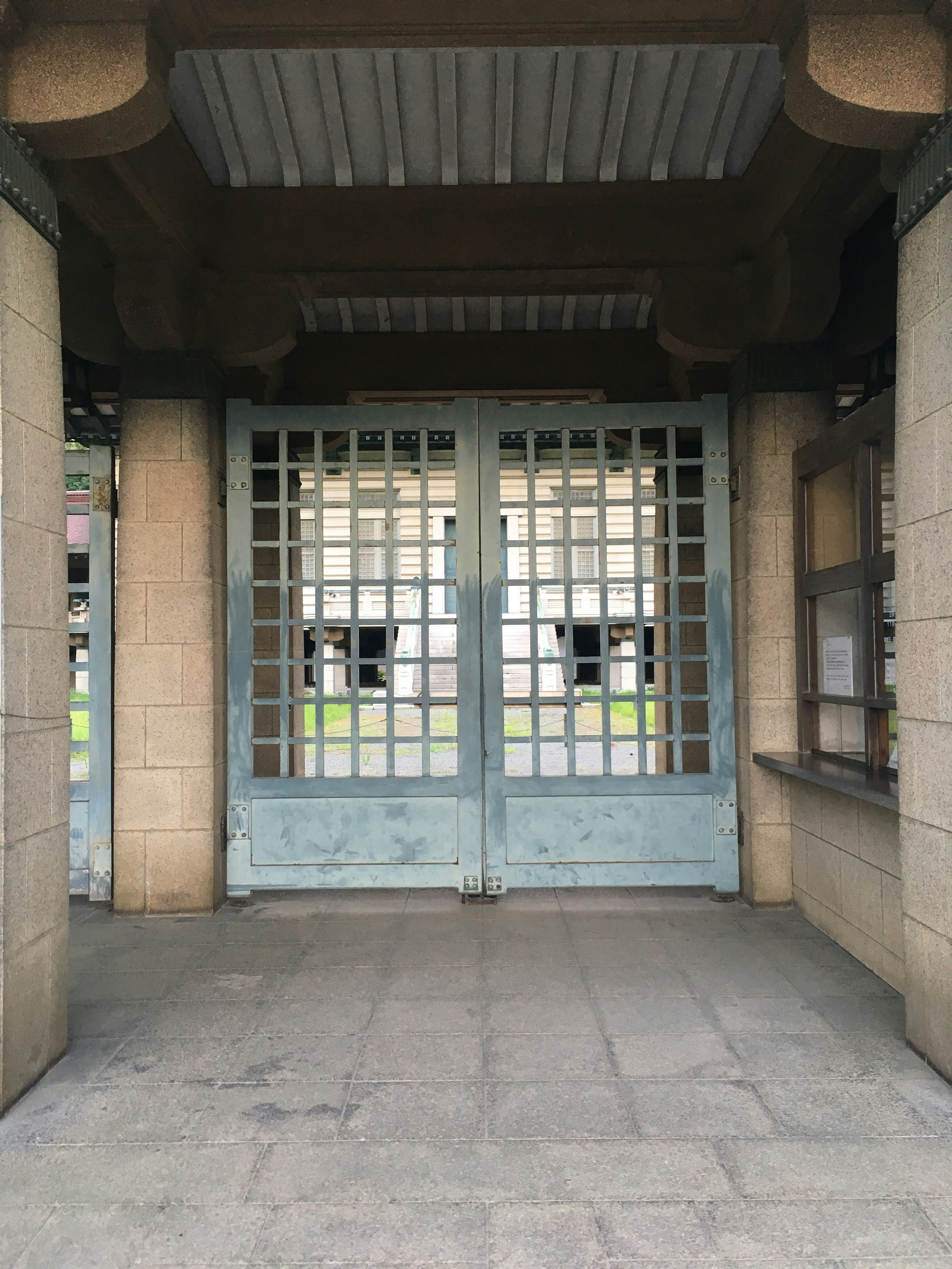 Entrada con puertas de rejilla azules y paredes de piedra