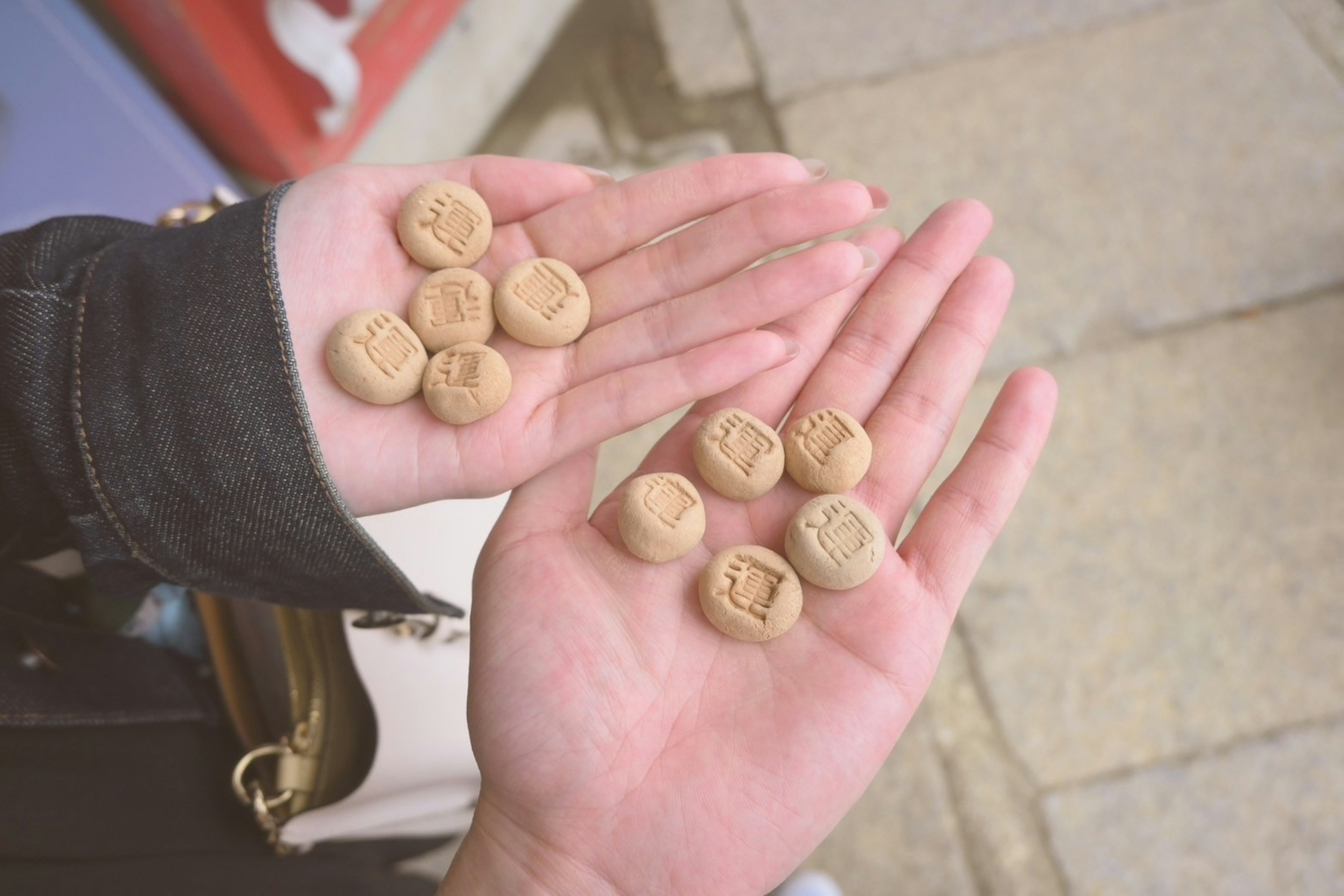 Zwei Hände halten runde keksartige Snacks, die in einem Muster angeordnet sind