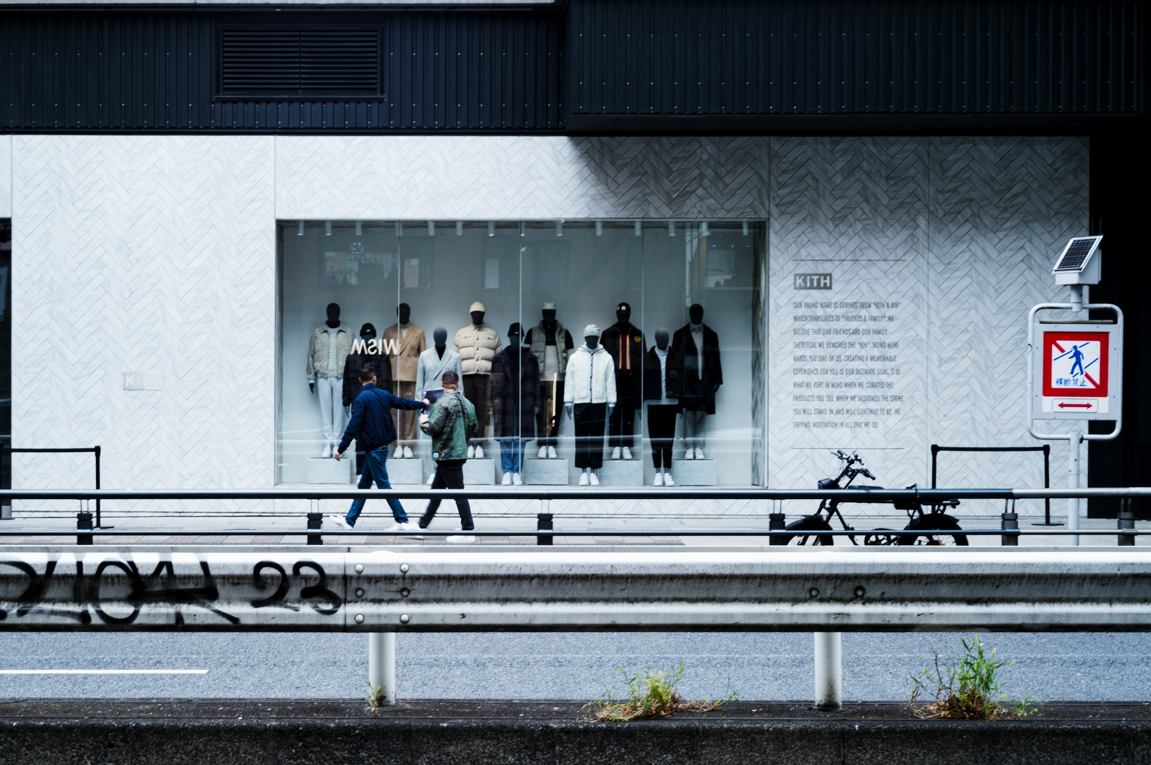 Schaufenster mit Kleidung und vorbeigehenden Passanten