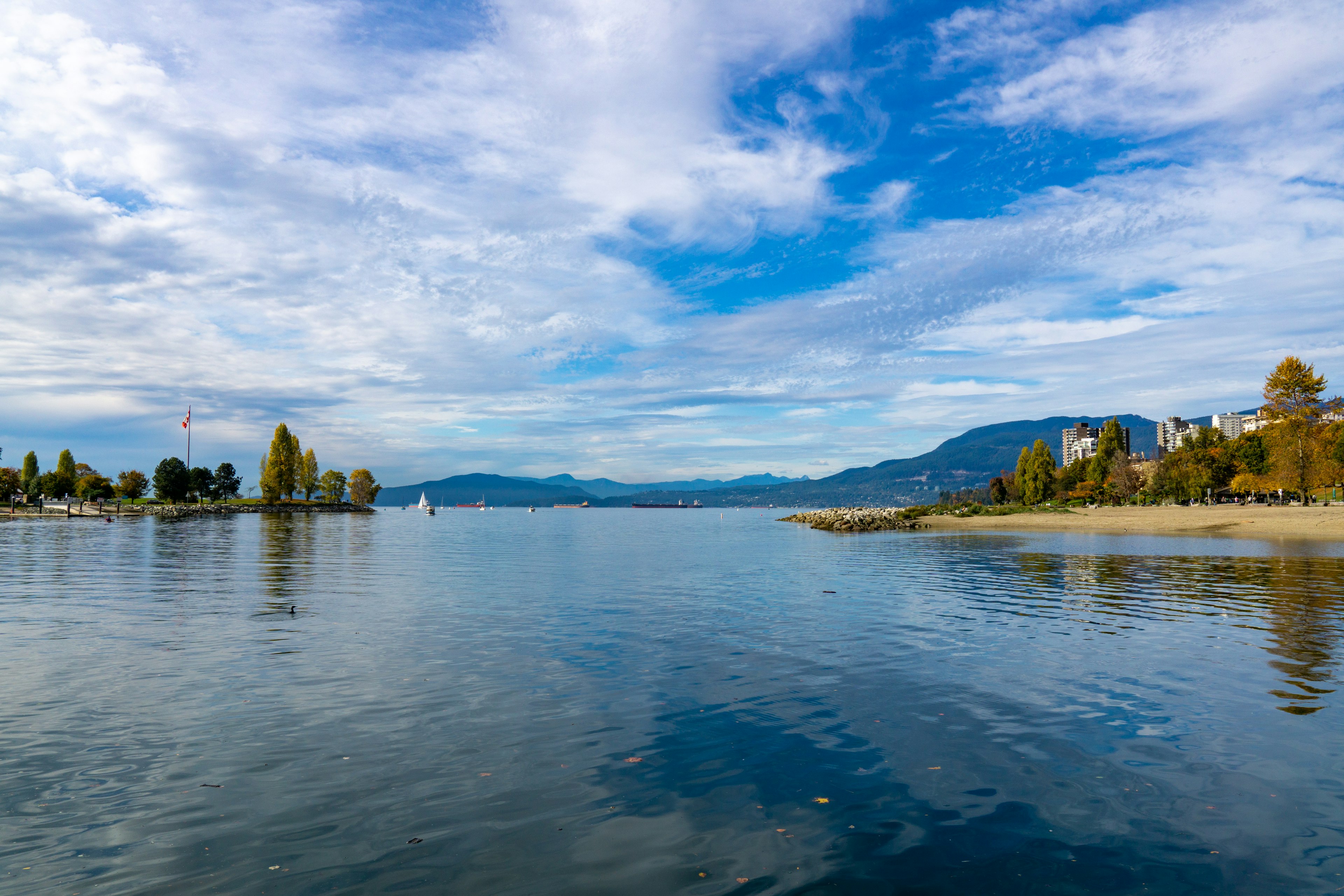 Ruhiger Seeblick mit blauem Himmel und reflektierten Bergen