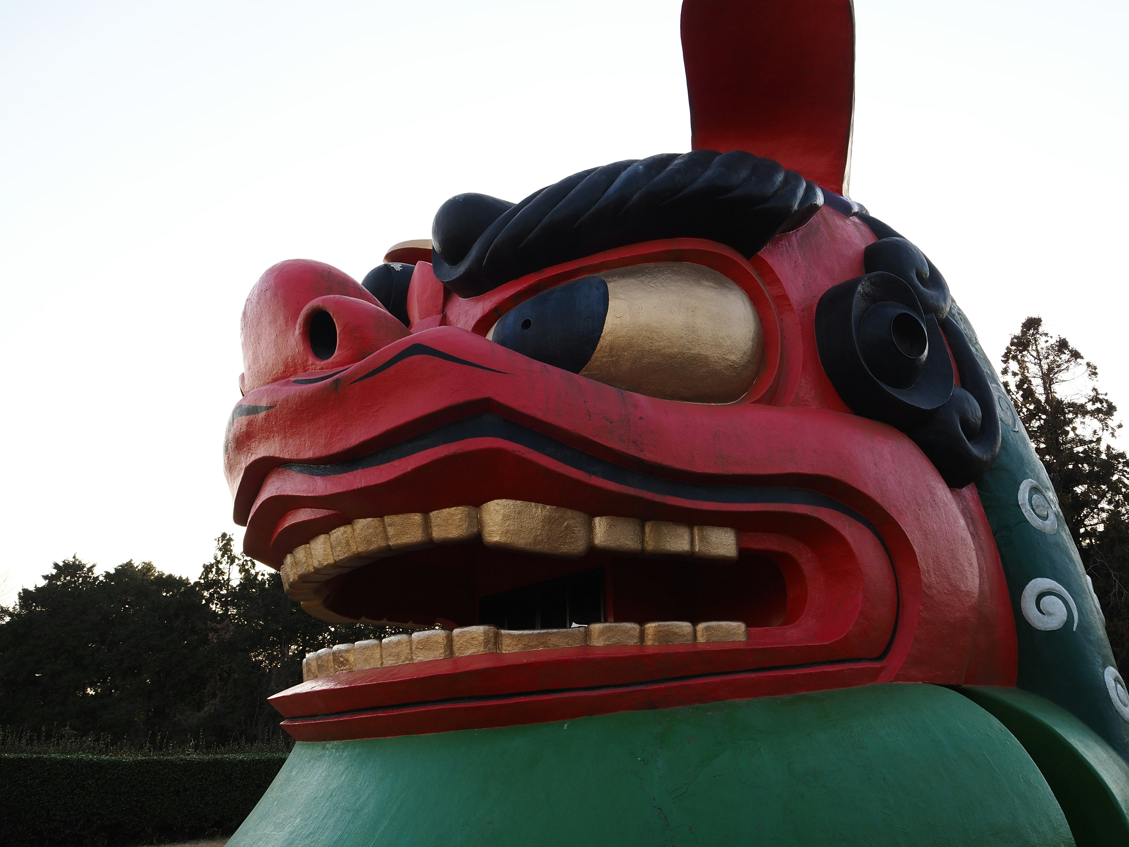 Una gran escultura de cabeza de león en colores rojo y verde