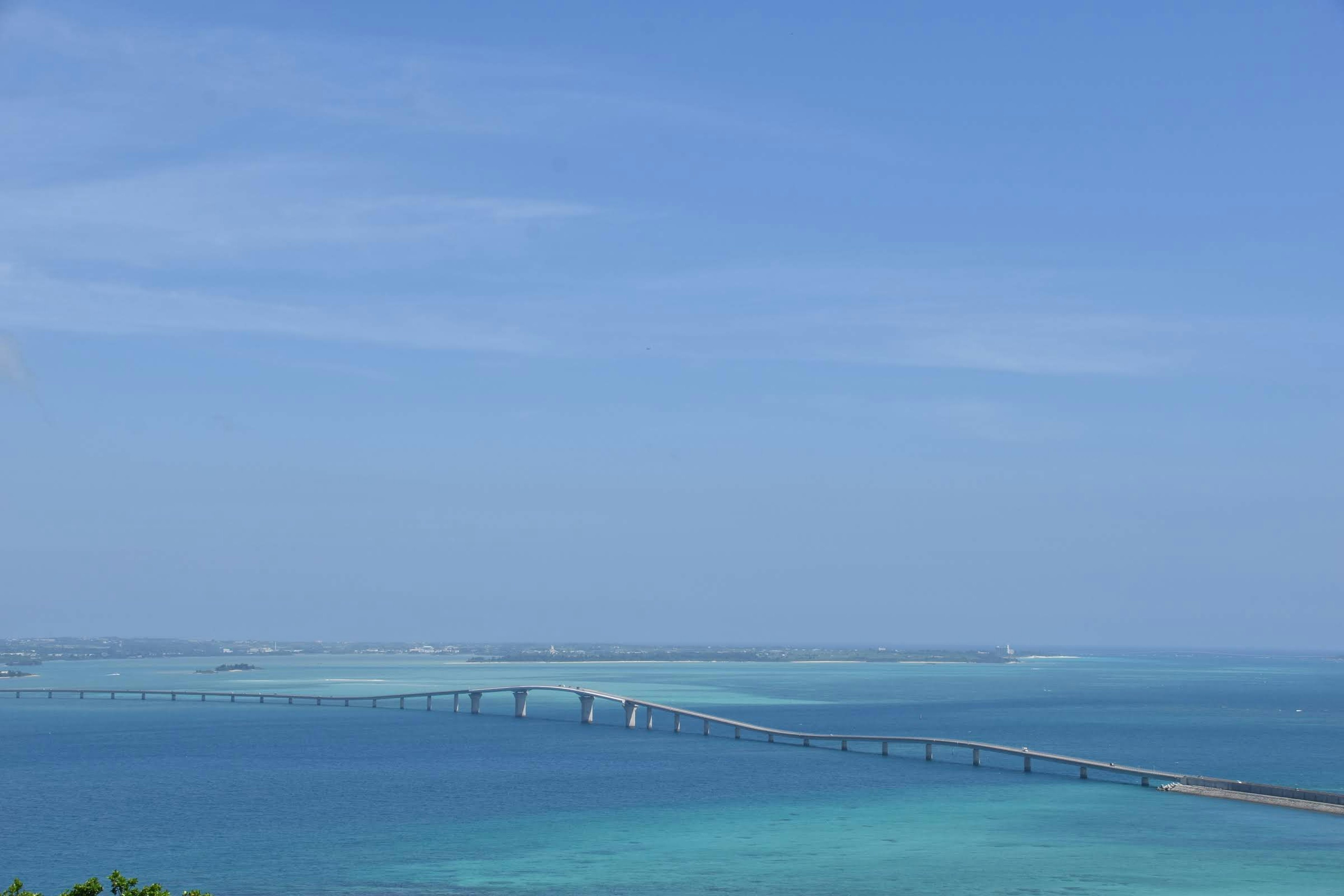 Una vista panoramica dell'oceano blu e del cielo con un ponte in lontananza