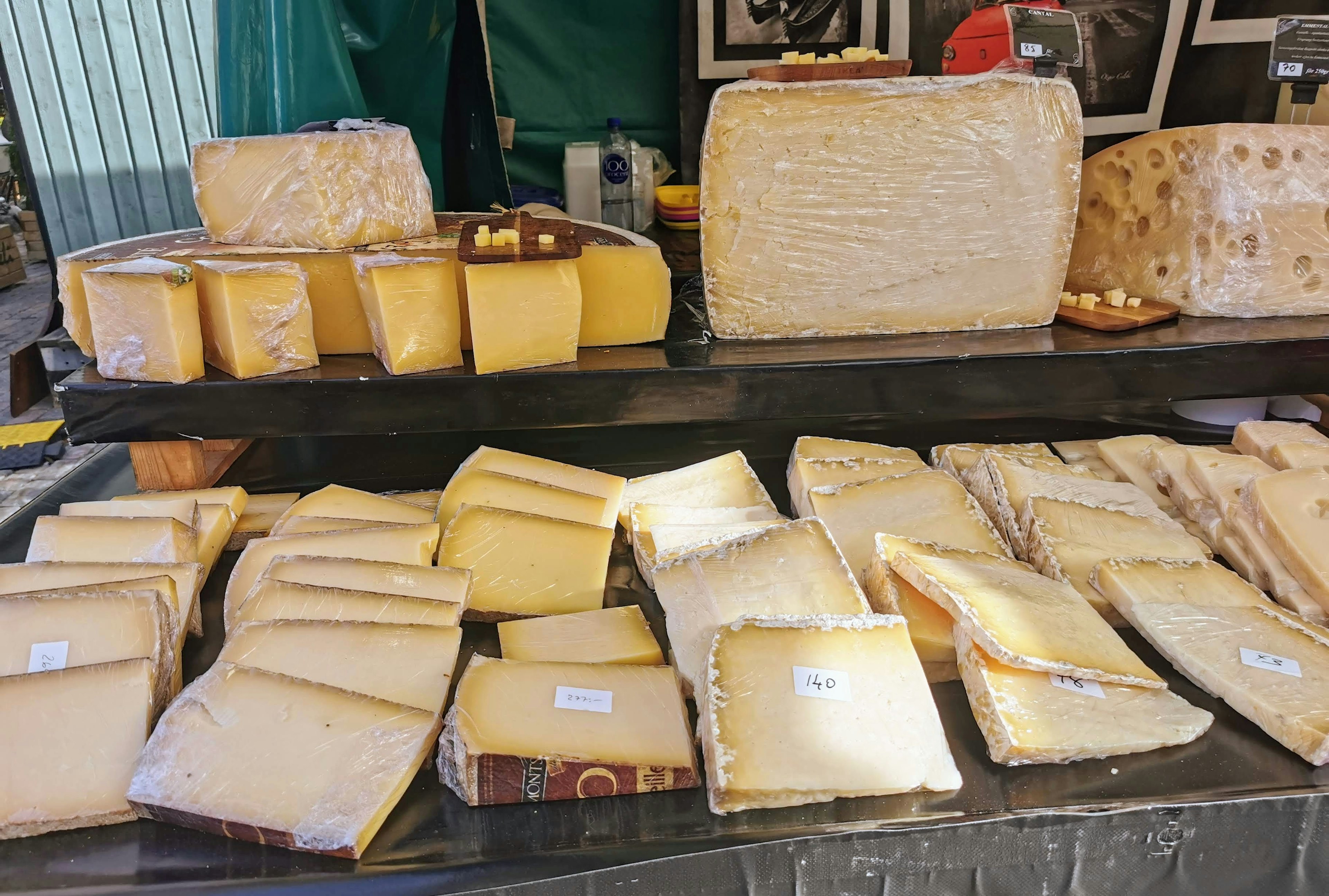 A variety of cheeses displayed at a market stall