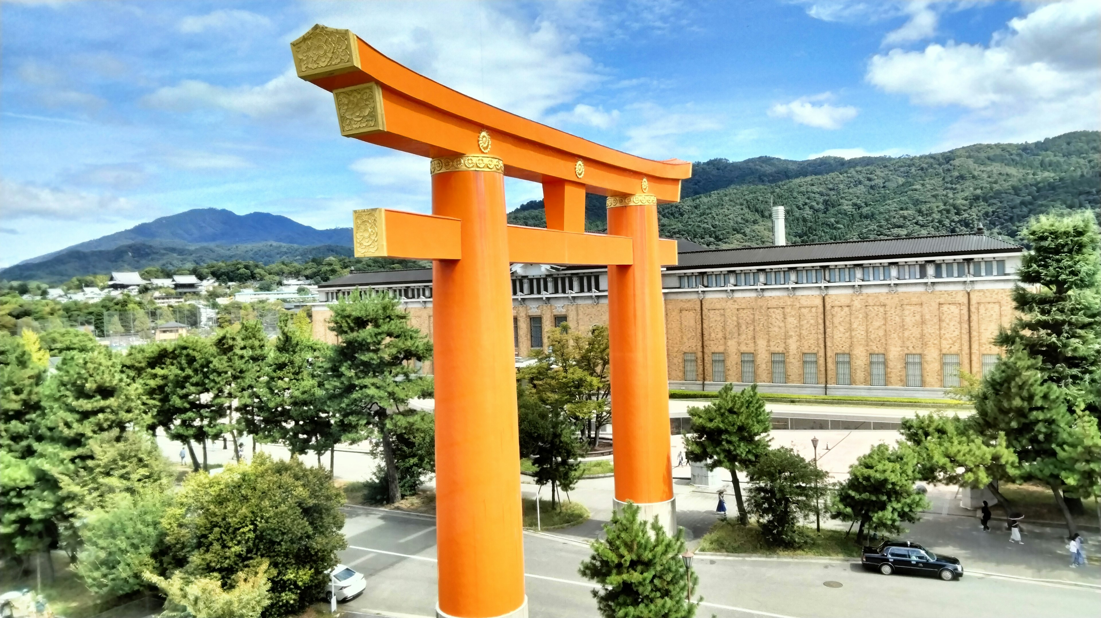 Cổng torii lớn màu cam với núi ở phía sau