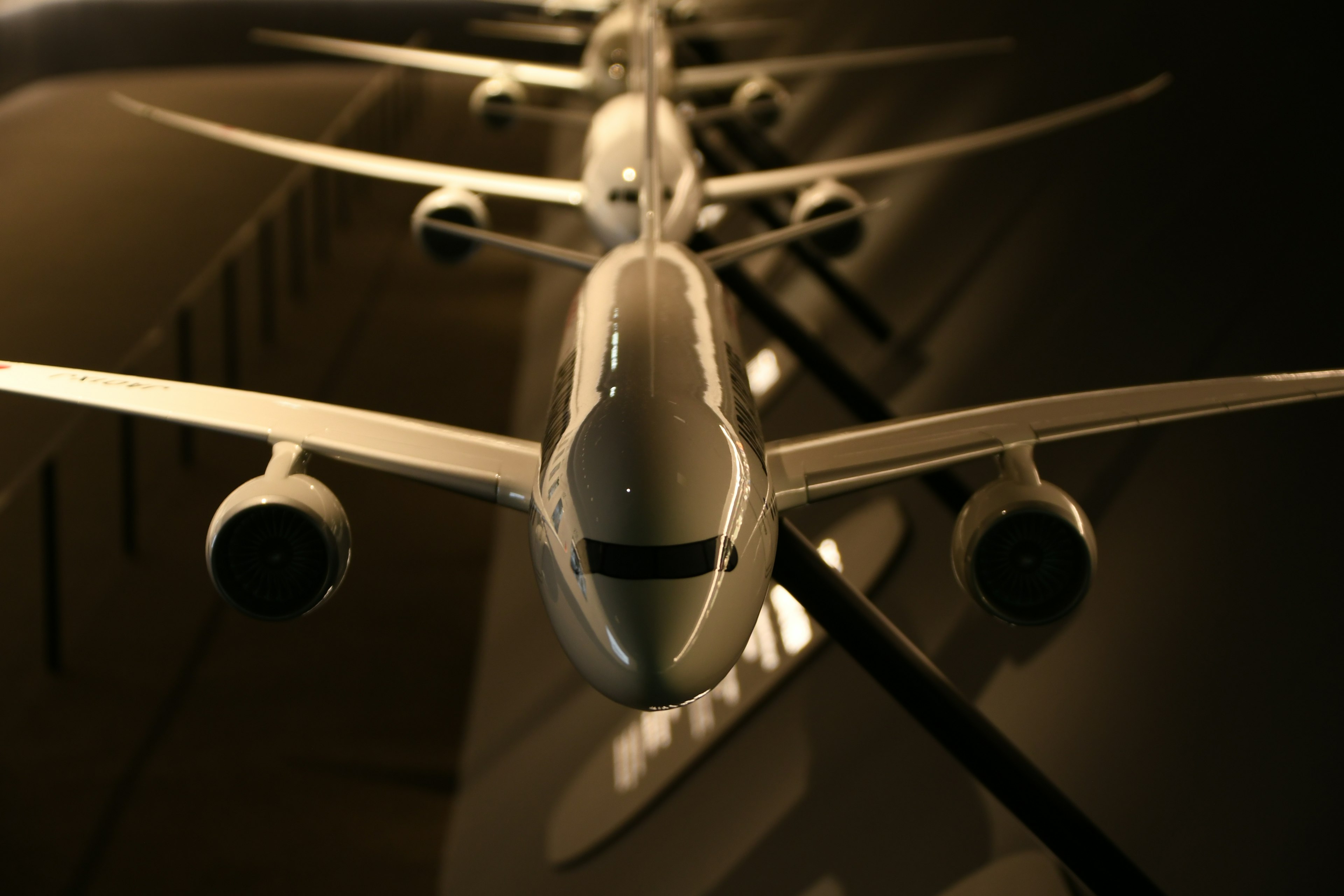 Models of airplanes lined up with dramatic lighting in a dark background