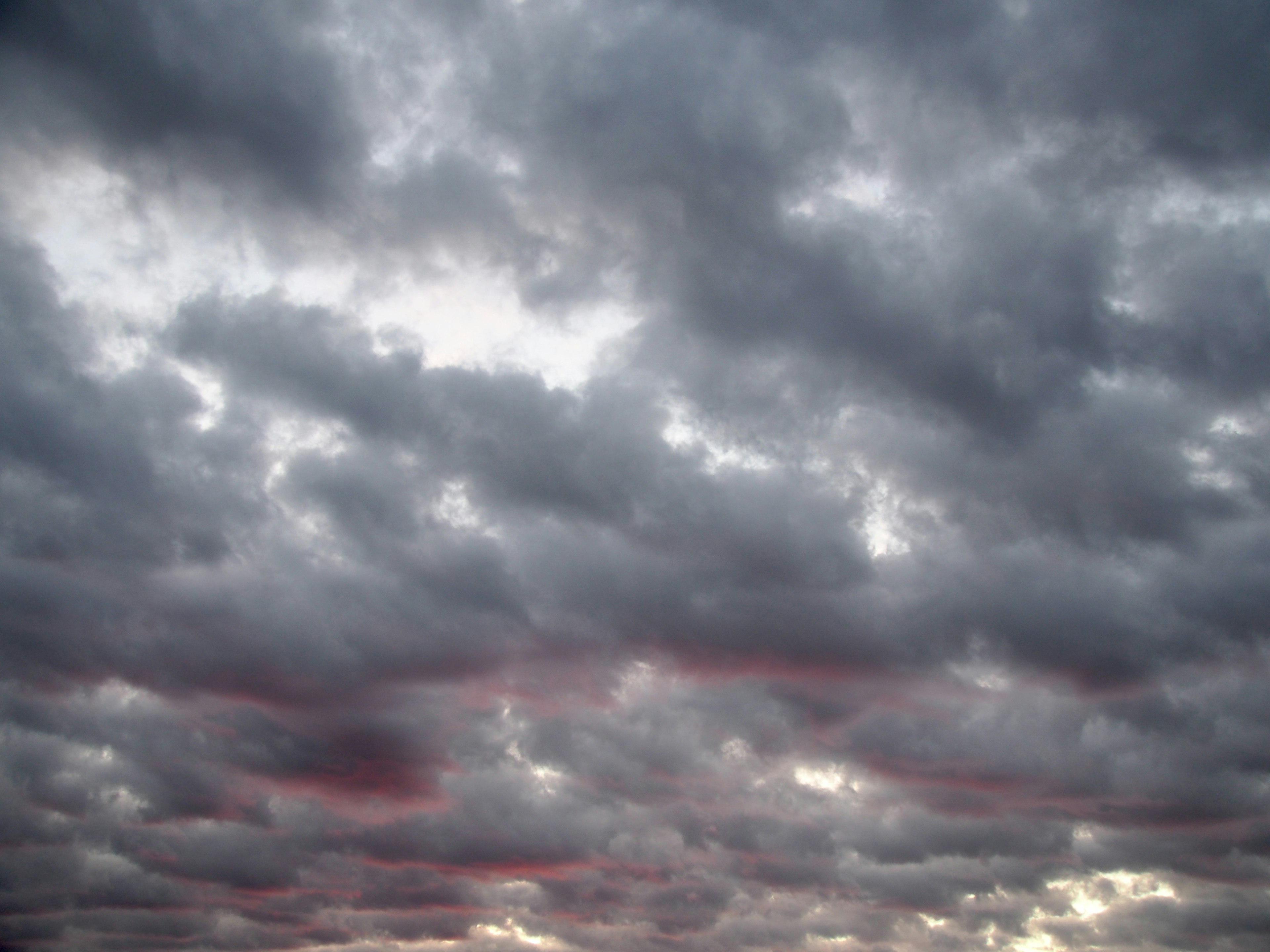 Bewölkter Himmel mit ausgebreiteten roten Wolken