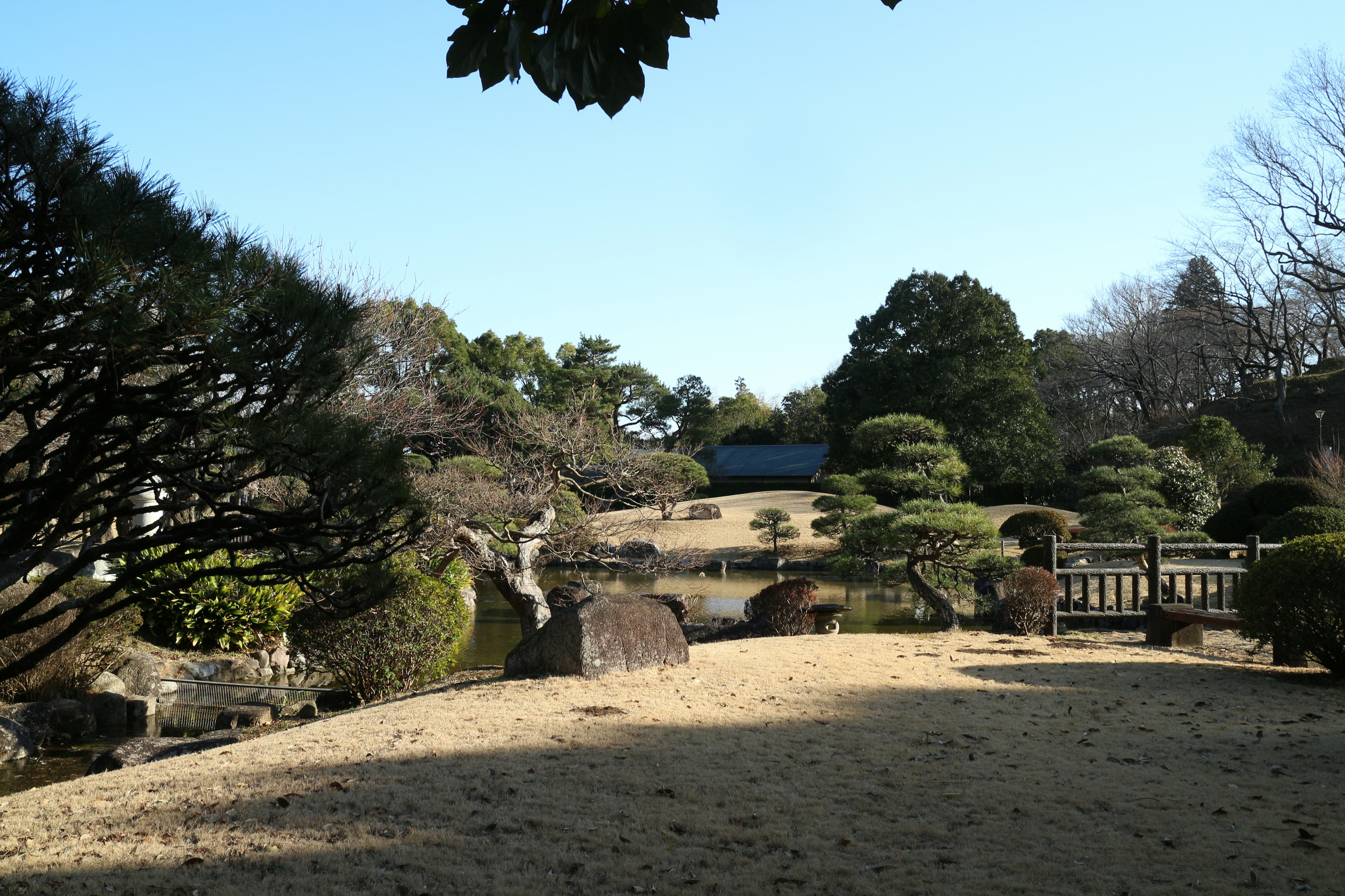 日本庭園的風景，綠樹成蔭，石頭strategically放置在寧靜的環境中