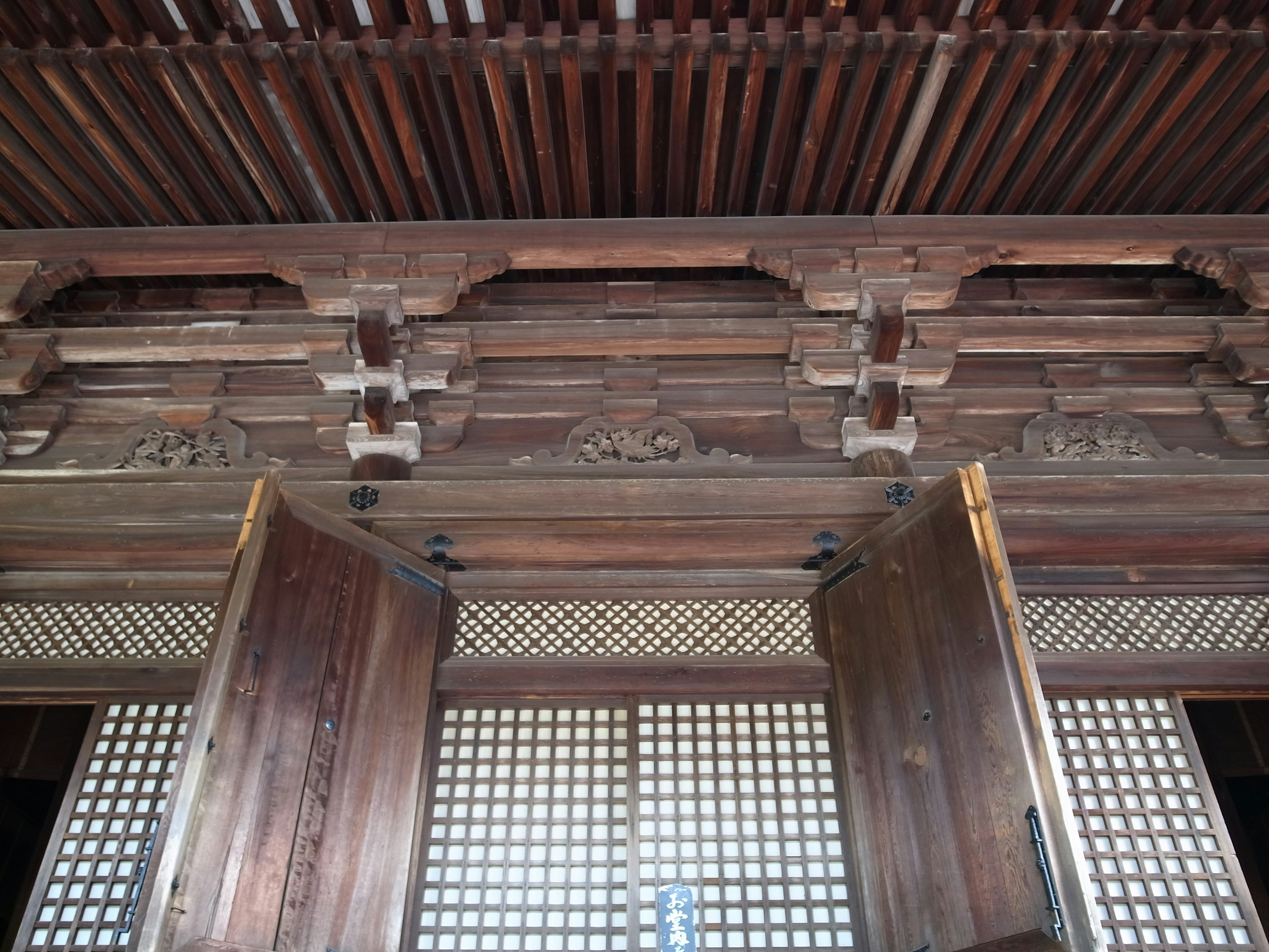 Interior of a traditional building featuring wooden doors and intricate lattice windows