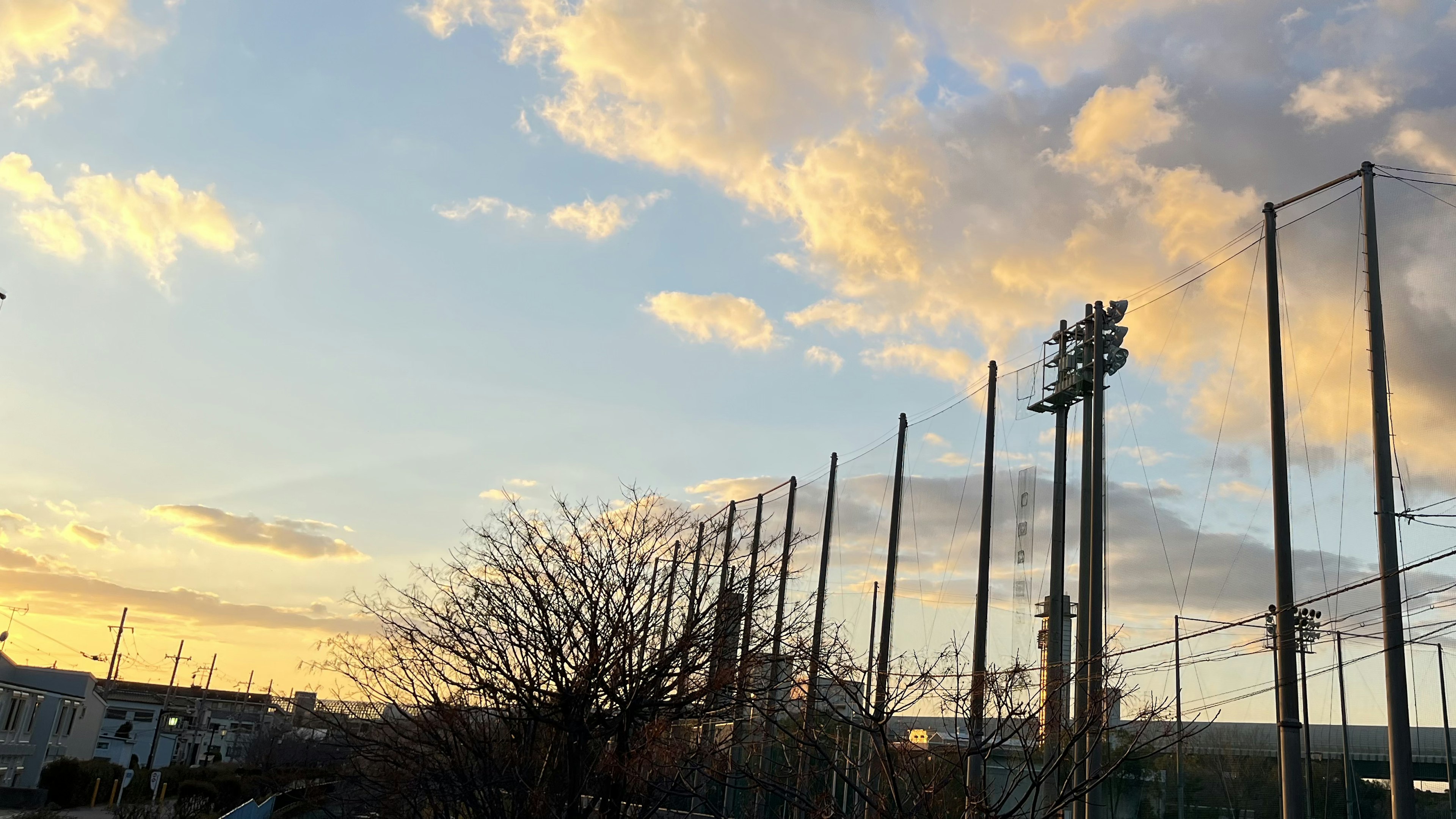 Langit senja dengan tiang penerangan lapangan baseball