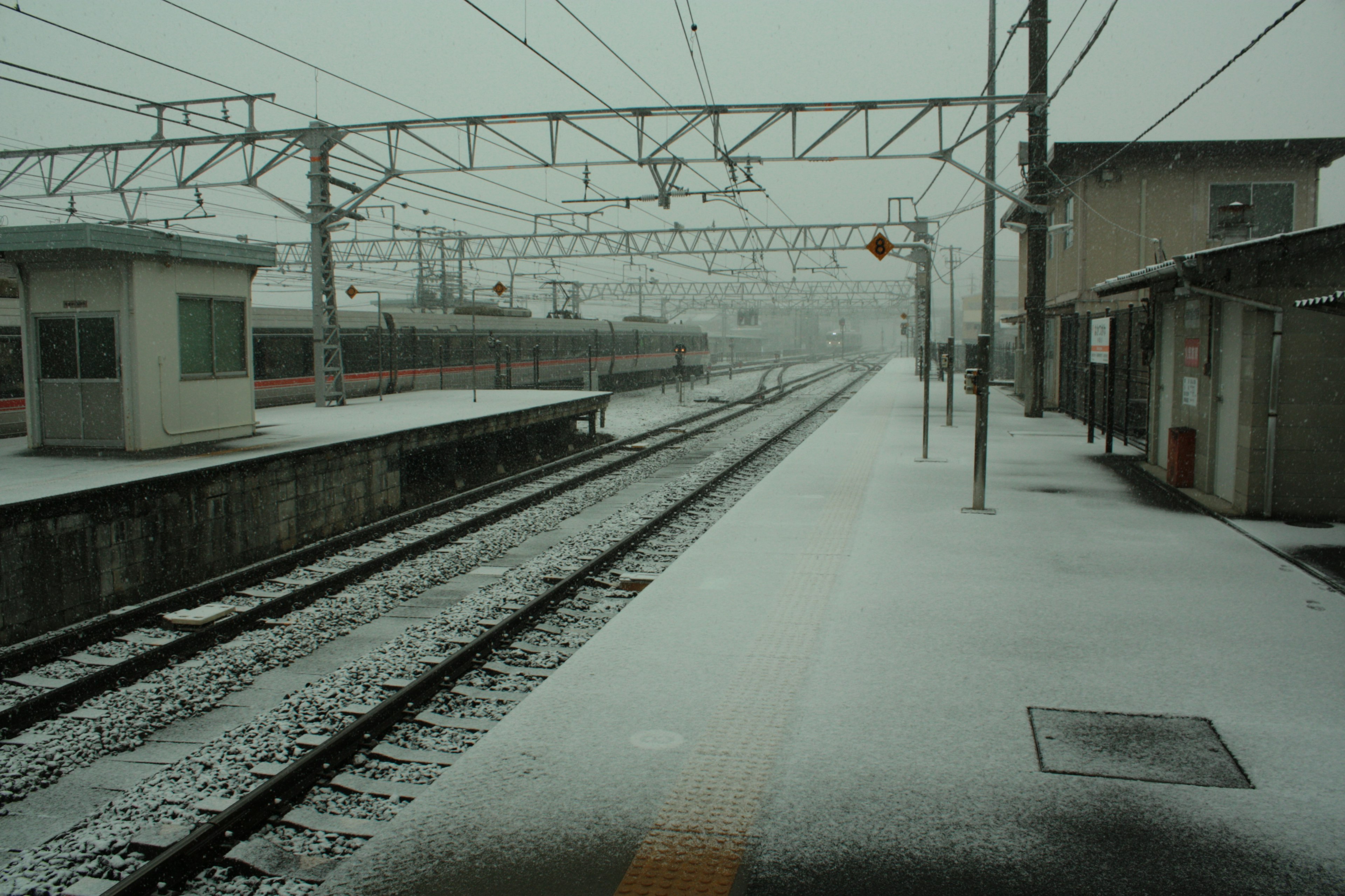 Snow-covered train station platform and tracks