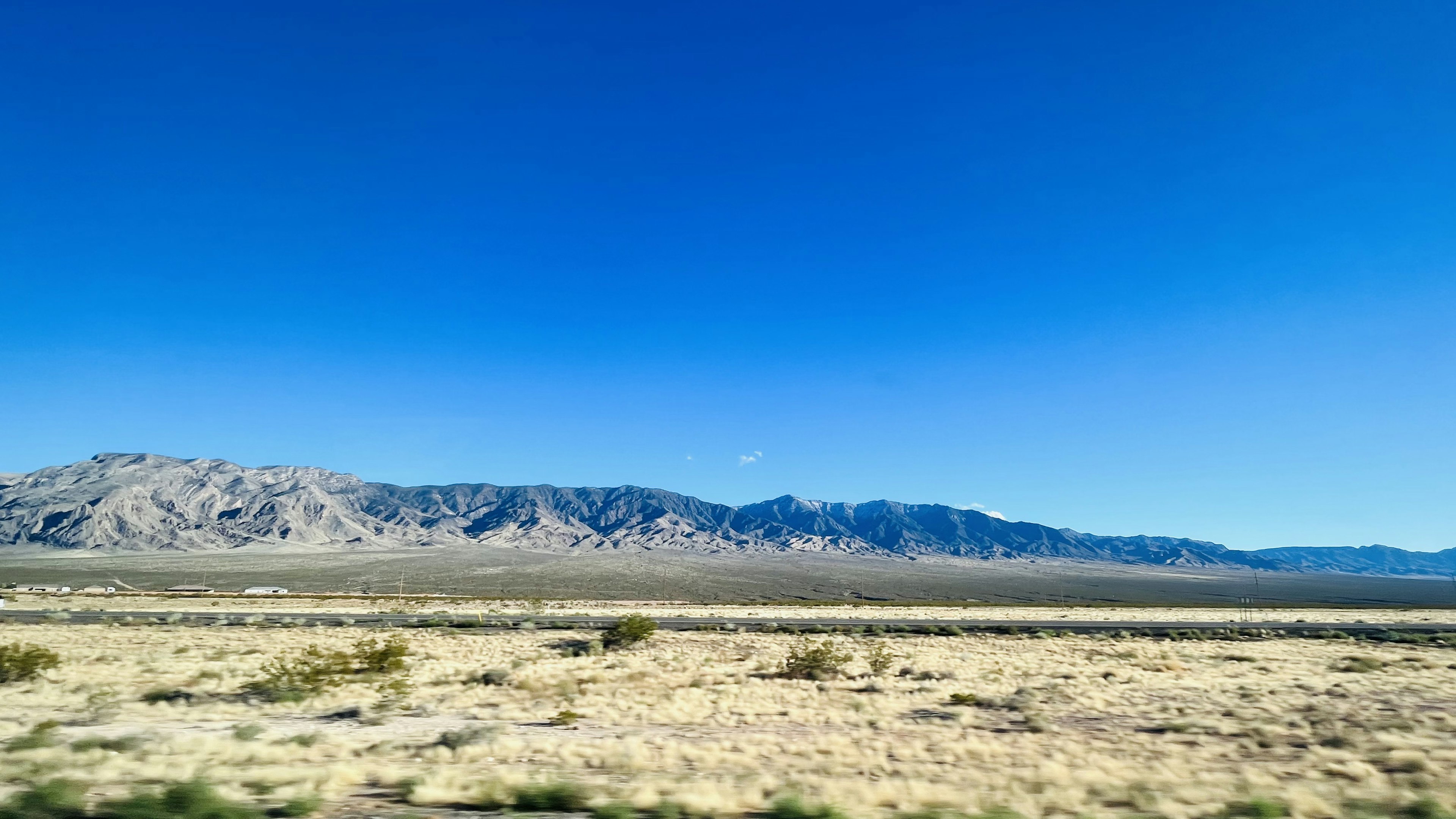 Un vaste paysage avec un ciel bleu clair et des montagnes au loin