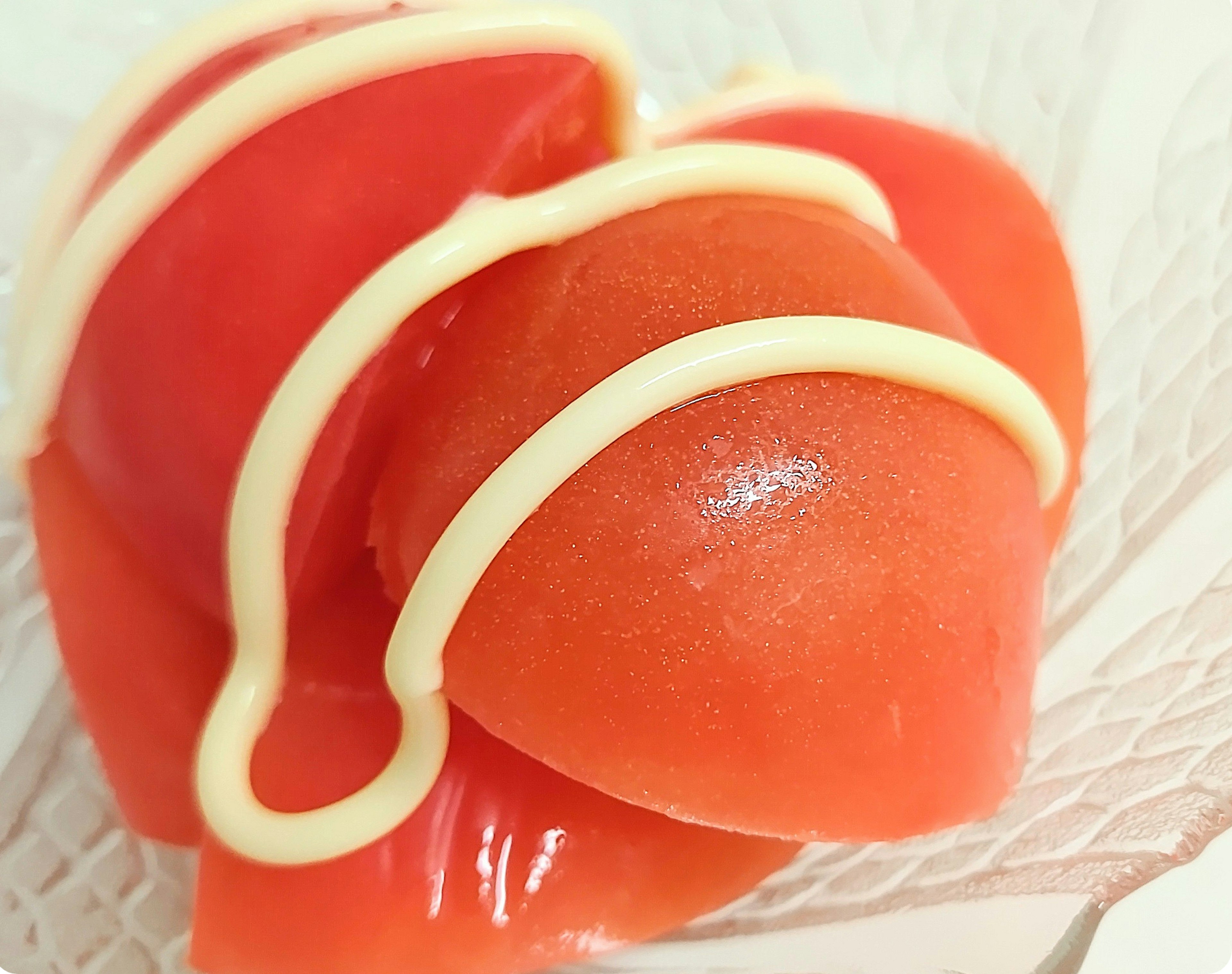 Postre de gelatina roja con una salsa similar a la mayonesa