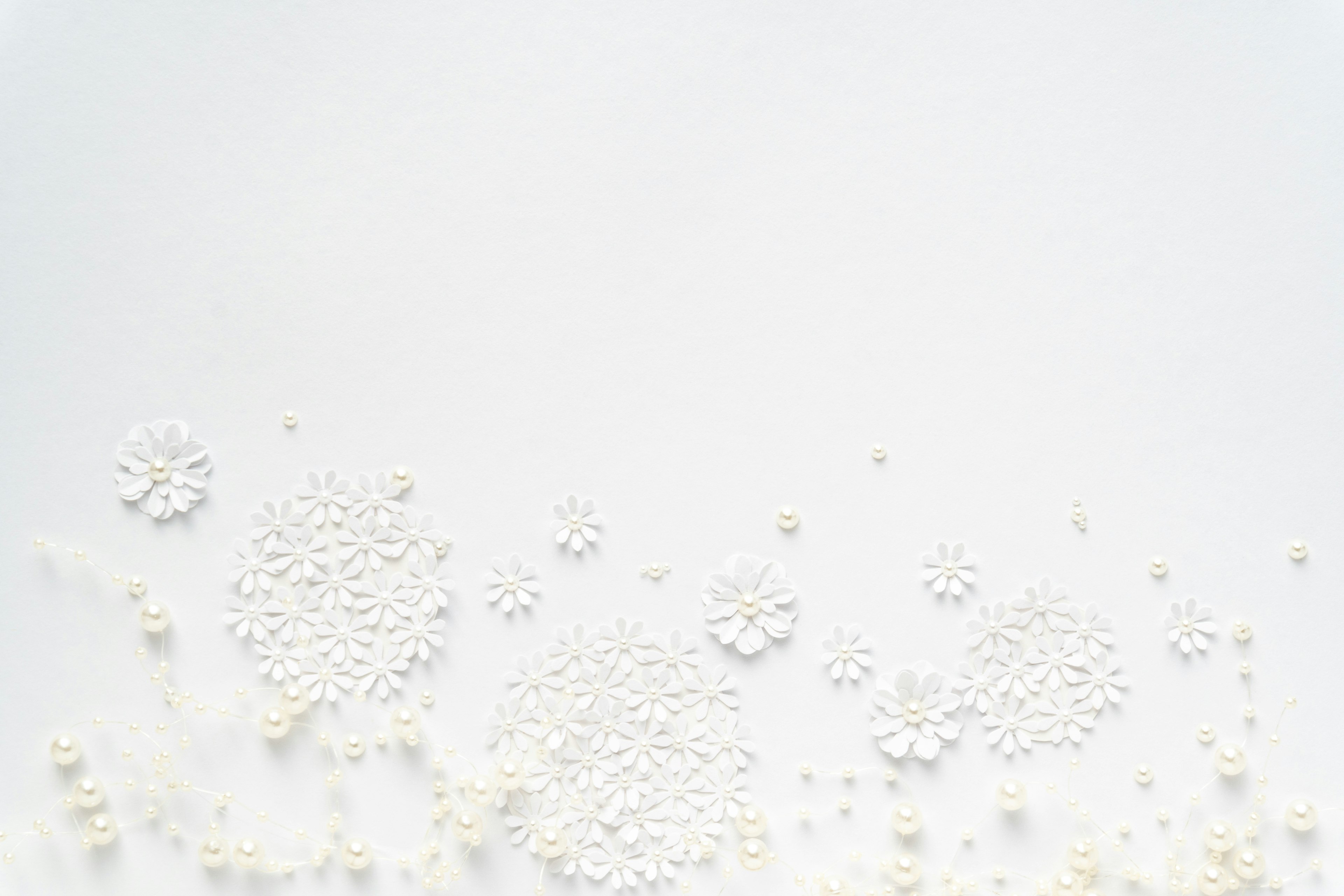 White background with white pearls and flower-shaped decorations