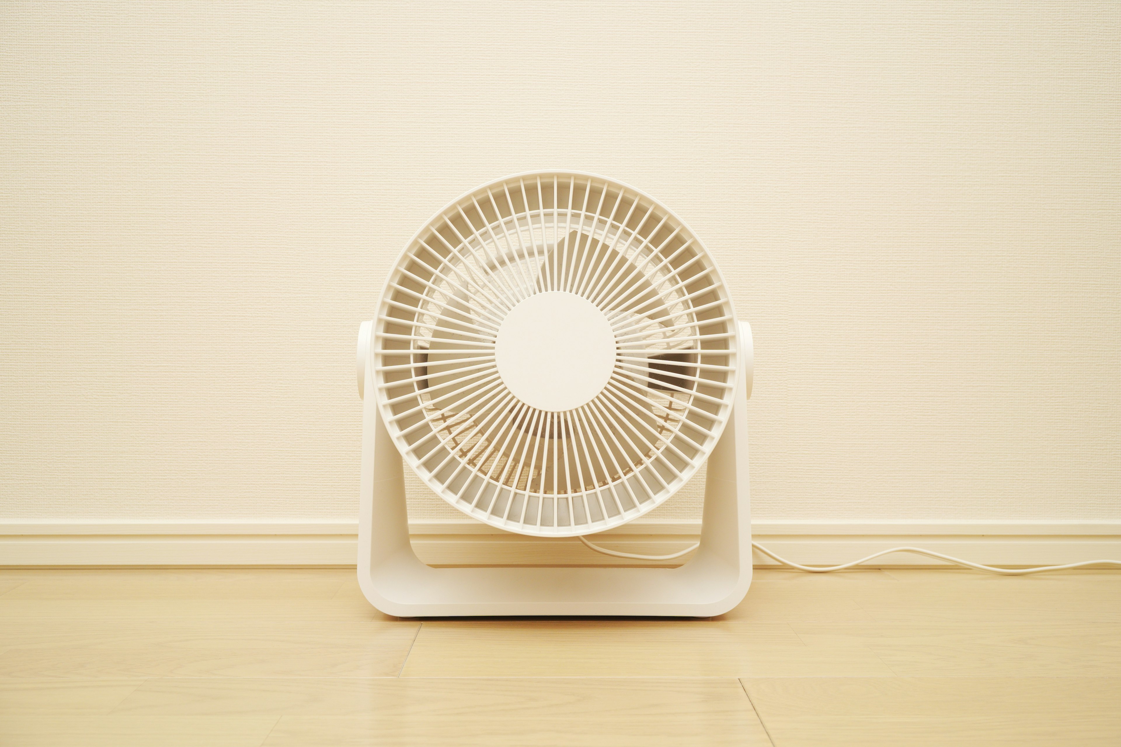 Un ventilador blanco colocado frente a una pared